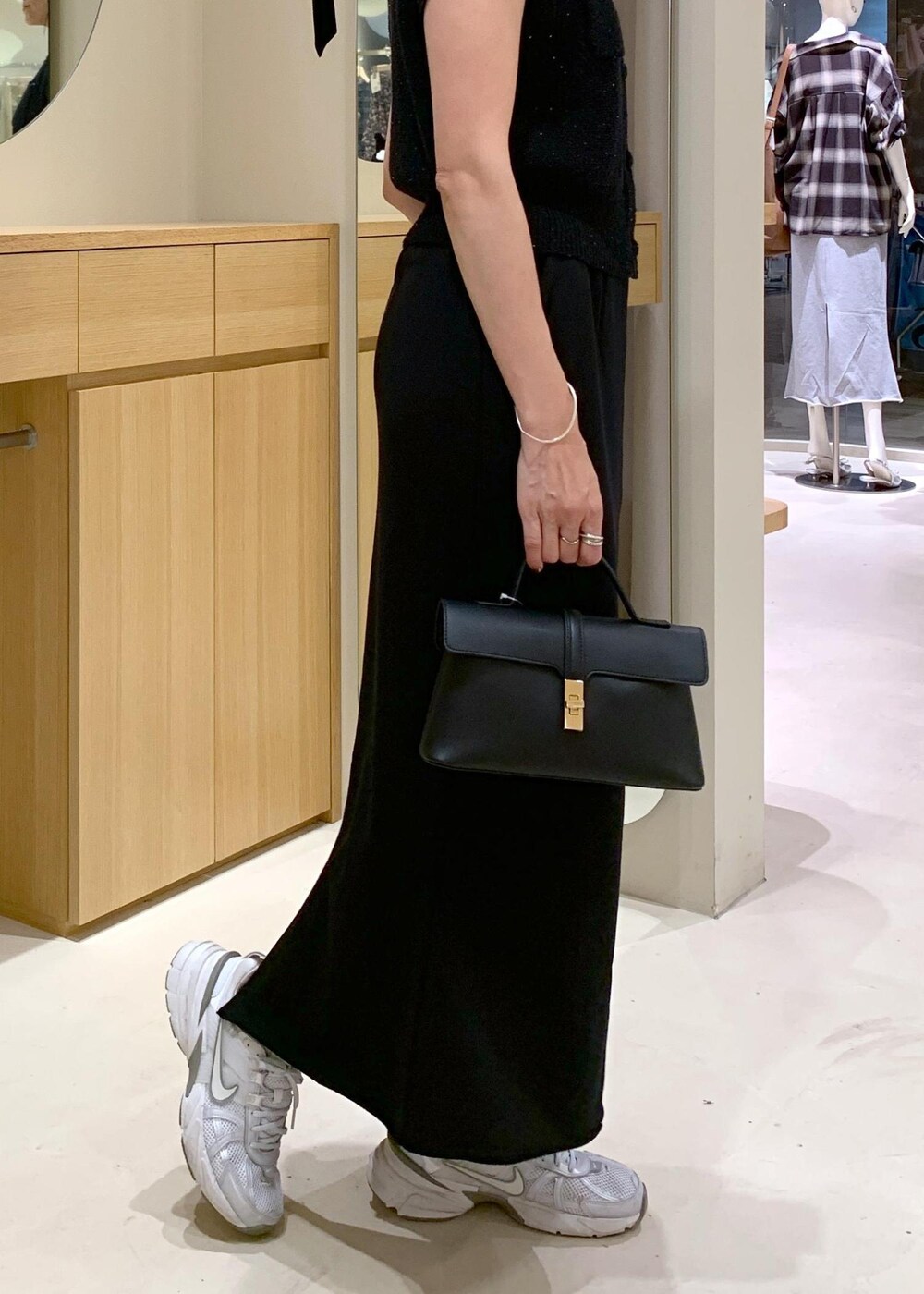 ブラック系のショルダーバッグ、ブラック系のカーディガン/ボレロ、ブラック系のキャミソールを着用したレディースの夏コーディネートの9枚目の写真