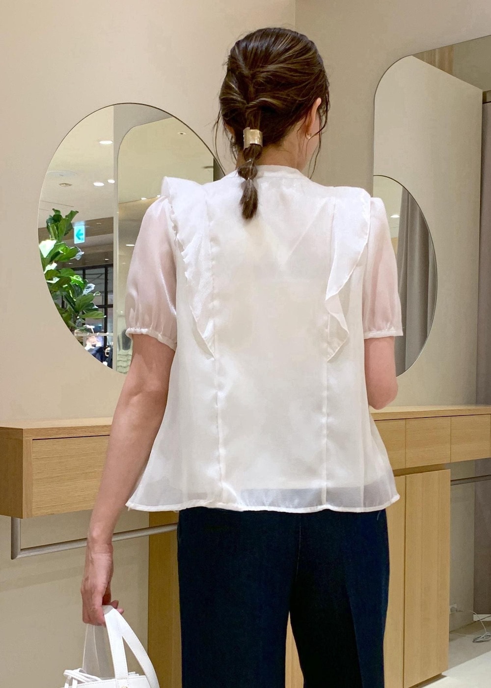 ホワイト系のキャミソール、ブラック系のサンダル、ブルー系のデニムパンツを着用したレディースの夏コーディネートの8枚目の写真