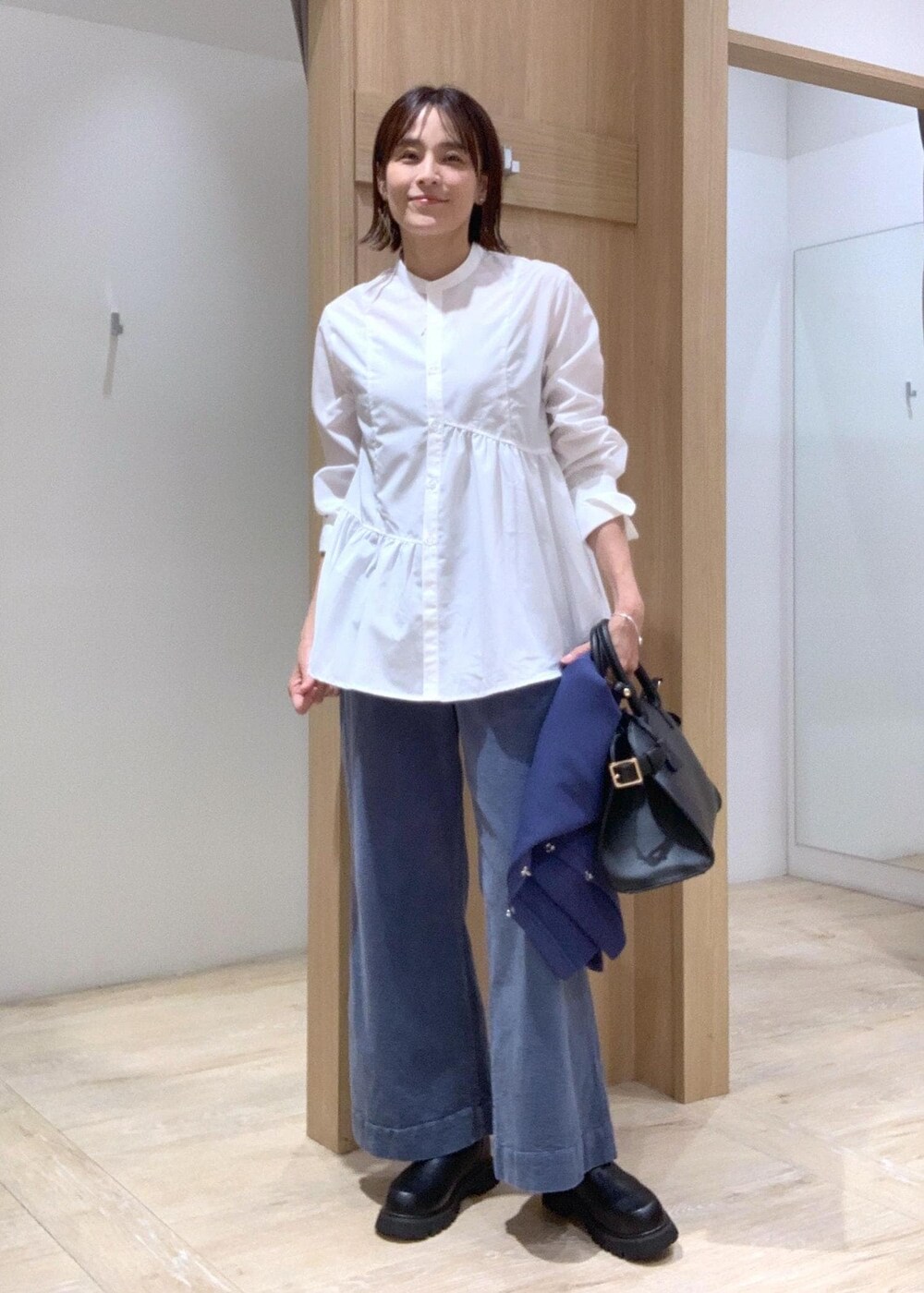 ブラック系のブーツ、ブラック系のトートバッグ、ブルー系のカーディガン/ボレロを着用したレディースの秋コーディネートの6枚目の写真