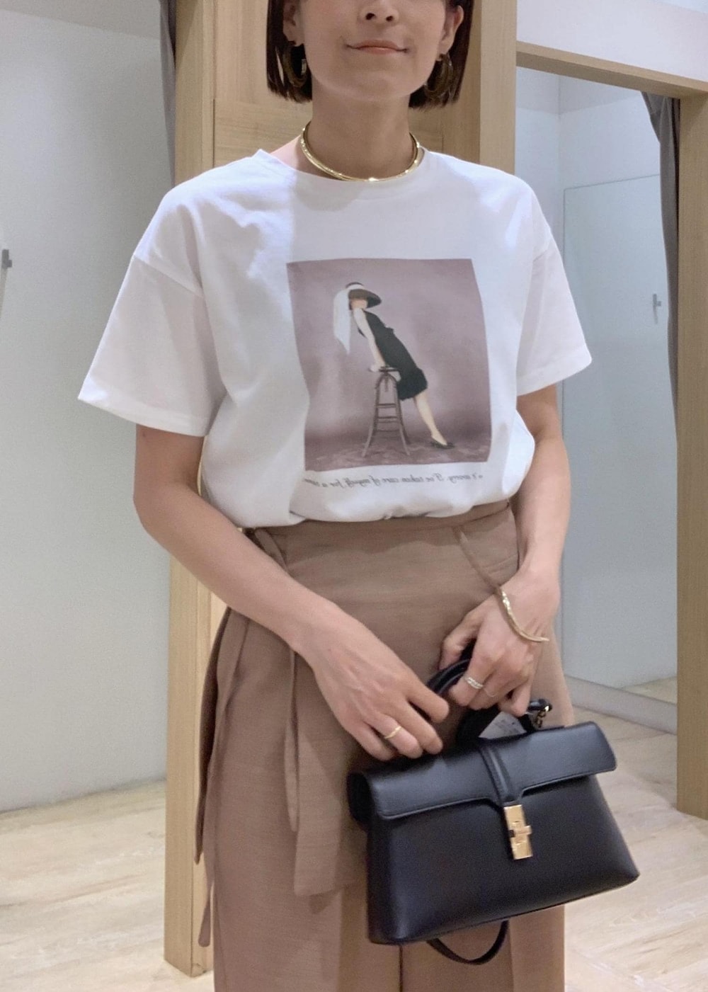 ホワイト系のTシャツ/カットソー、その他のサンダル、ブラウン系のスラックスを着用したレディースの夏コーディネートの7枚目の写真
