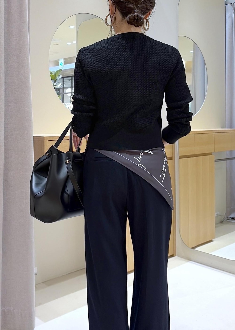 ブラック系のキャミソール、ブルー系のその他パンツ、ブラック系のビジネスバッグを着用したレディースの秋コーディネートの7枚目の写真