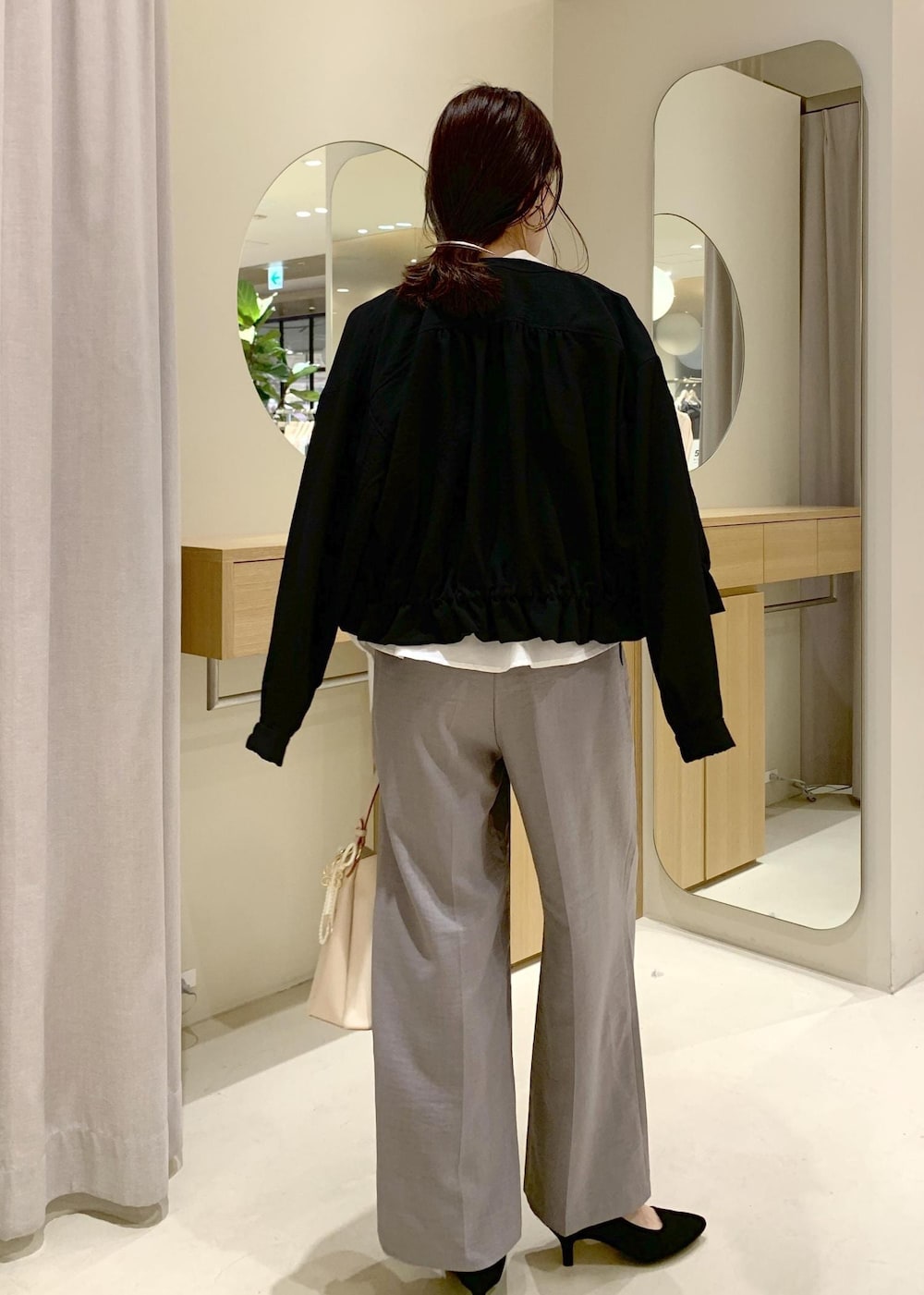 ベージュ系のショルダーバッグ、ブラック系のブルゾン、グレー系のシャツ/ブラウスを着用したレディースの春コーディネートの4枚目の写真