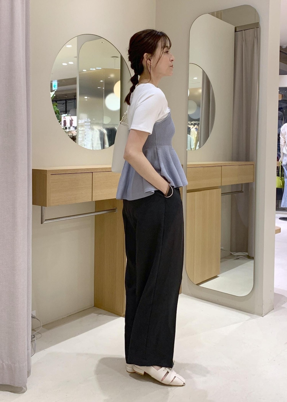 ホワイト系のショルダーバッグ、グレー系のその他パンツ、ホワイト系のパンプスを着用したレディースの春コーディネートの3枚目の写真