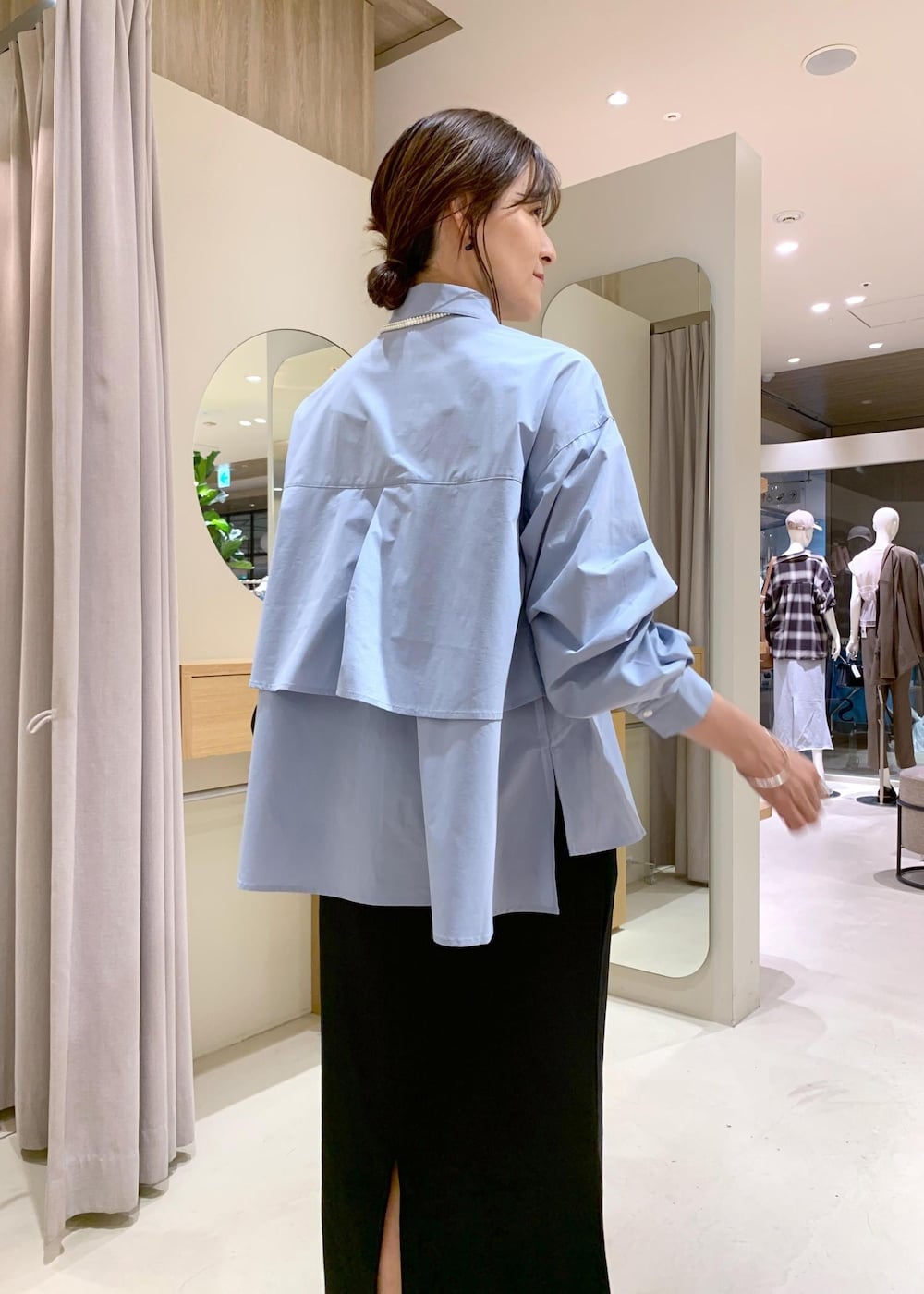 ブラック系のパンプス、ブラック系のスカート、ブルー系のシャツ/ブラウスを着用したレディースの夏コーディネートの7枚目の写真