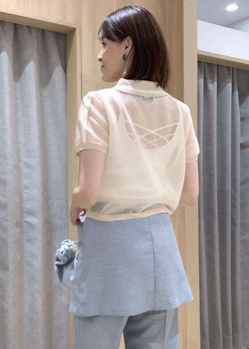 ホワイト系のサンダル、ブルー系のスラックス、ブルー系のハンドバッグを着用したレディースの夏コーディネートの7枚目の写真