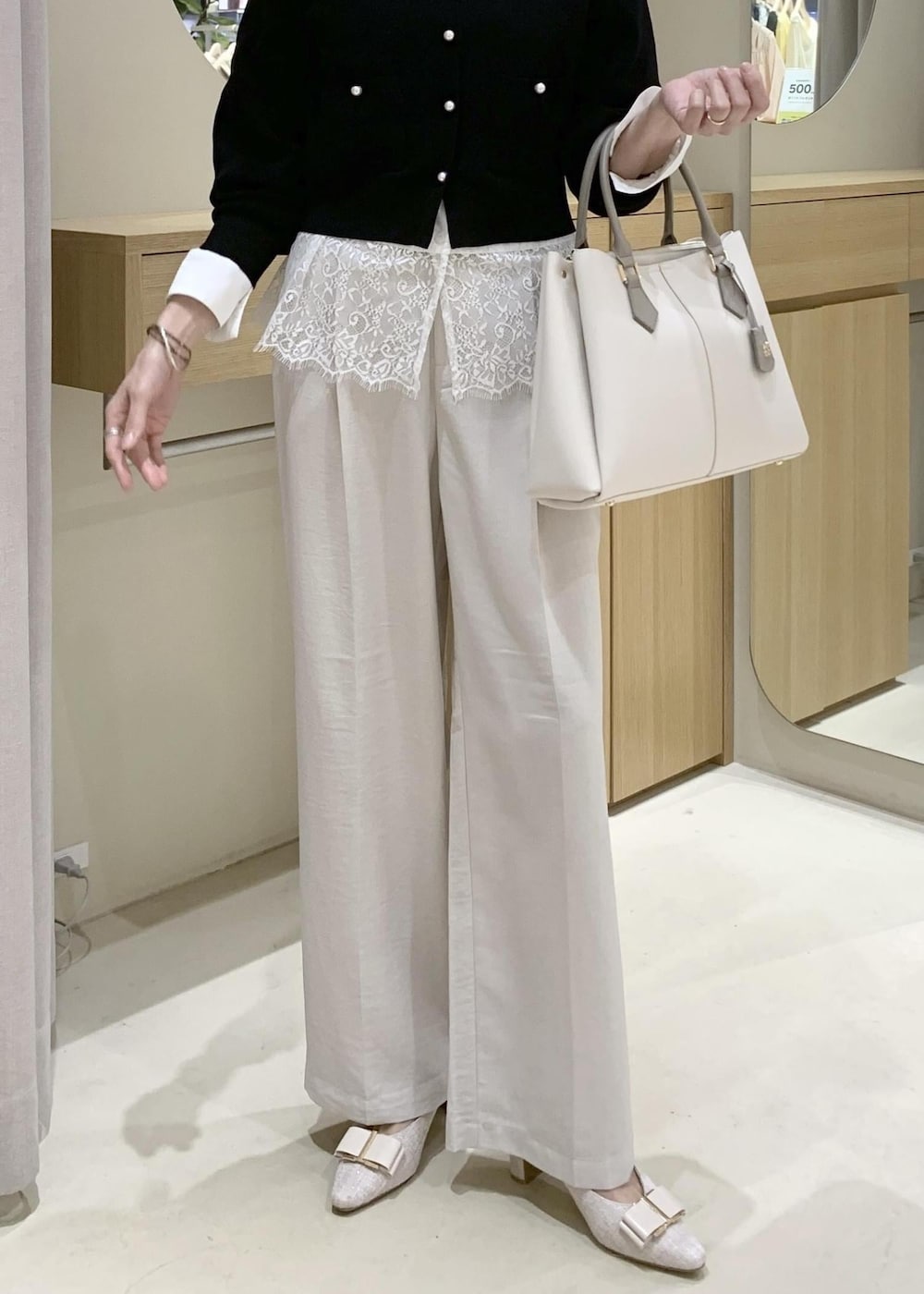 ベージュ系のパンプス、ホワイト系のシャツ/ブラウス、ブラック系のカーディガン/ボレロを着用したレディースの春コーディネートの6枚目の写真