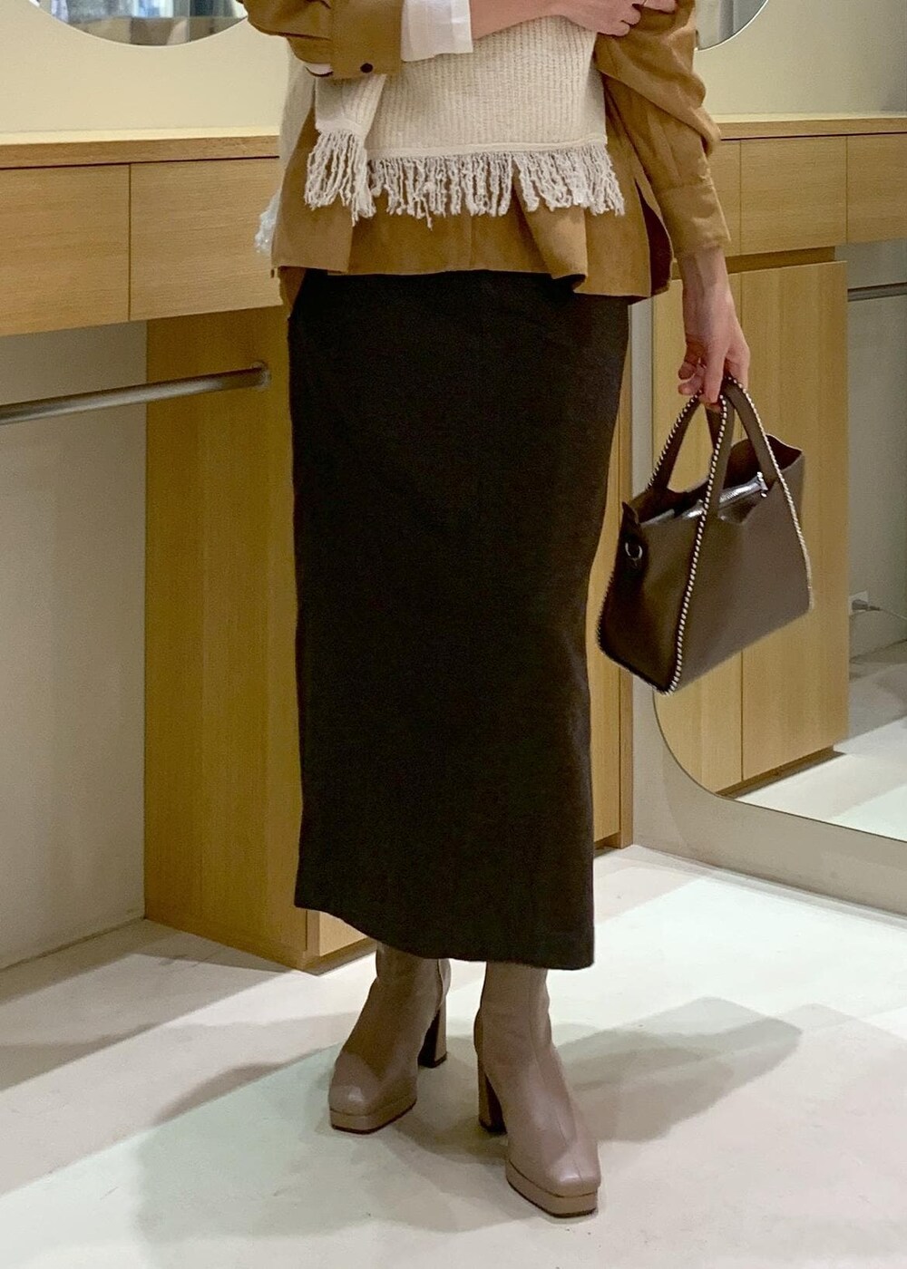 ベージュ系のブーツ、ブラウン系のスカート、イエロー系のシャツ/ブラウスを着用したレディースの秋コーディネートの8枚目の写真