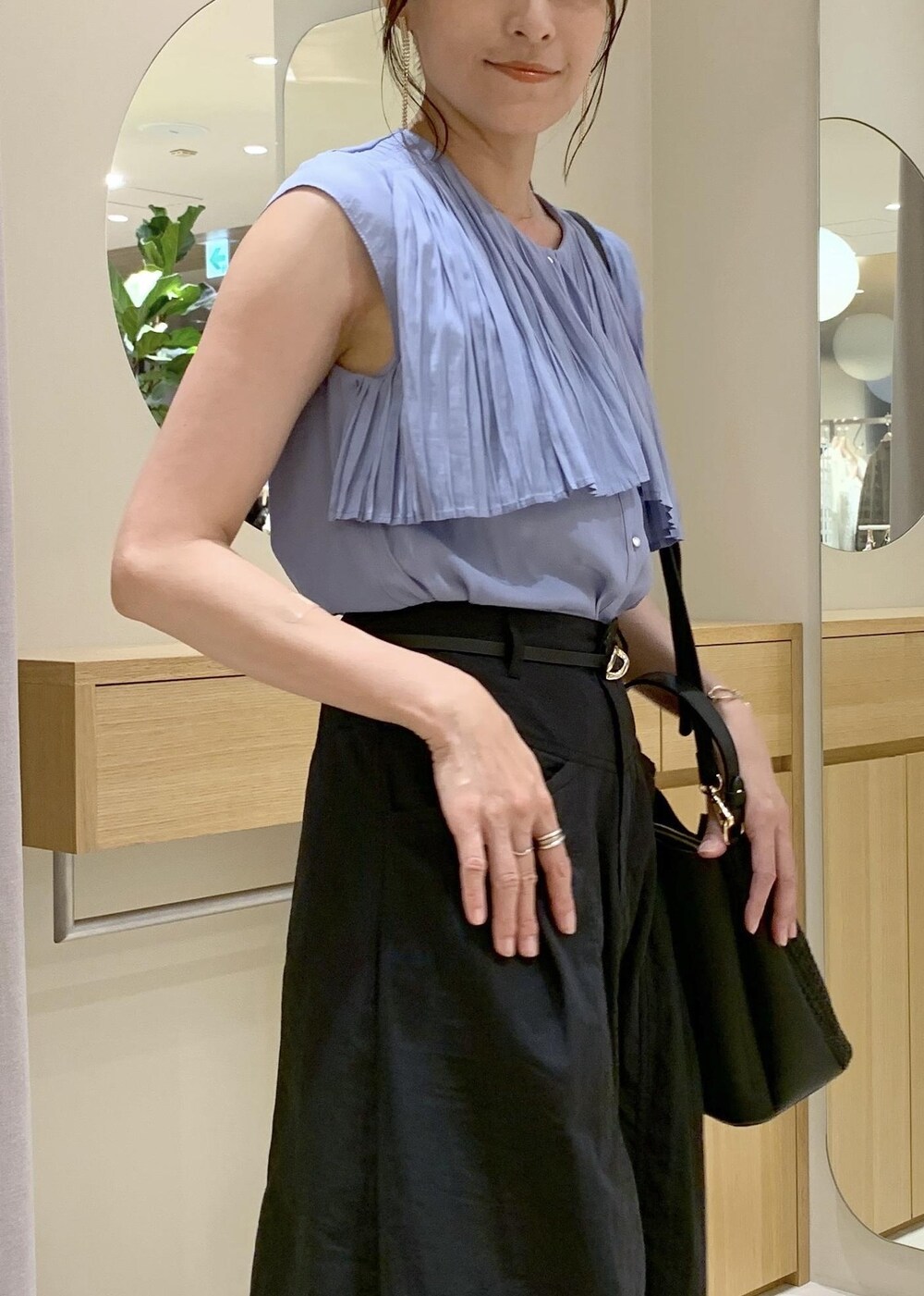 ブラック系のショルダーバッグ、ブルー系のシャツ/ブラウス、ブラック系のスカートを着用したレディースの夏コーディネートの5枚目の写真