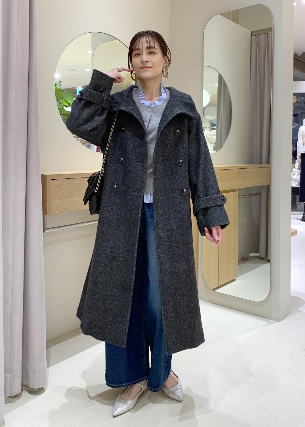 ブルー系のデニムパンツ、グレー系のその他アウター、ブラック系のショルダーバッグを着用したレディースの冬コーディネートの2枚目の写真