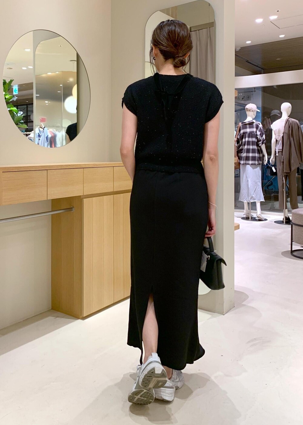 ブラック系のショルダーバッグ、ブラック系のカーディガン/ボレロ、ブラック系のキャミソールを着用したレディースの夏コーディネートの4枚目の写真