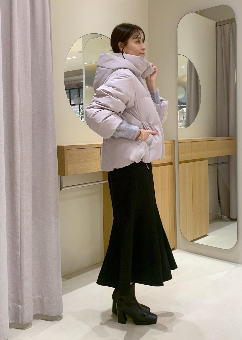 ブラック系のショルダーバッグ、ブラック系のブーツ、ブラック系のスカートを着用したレディースの秋コーディネートの4枚目の写真