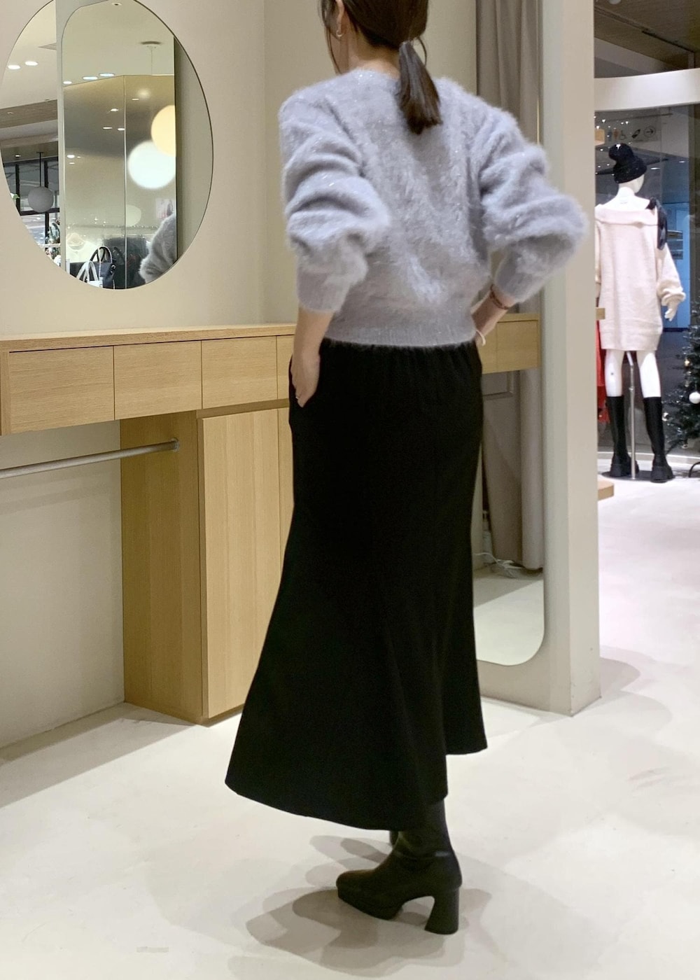 ブラック系のショルダーバッグ、ブラック系のブーツ、ブラック系のスカートを着用したレディースの秋コーディネートの8枚目の写真