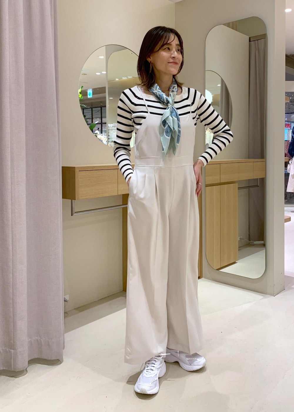 グレー系のショルダーバッグ、ホワイト系のニット/セーター、ブルー系のテーラードジャケットを着用したレディースの冬コーディネートの6枚目の写真