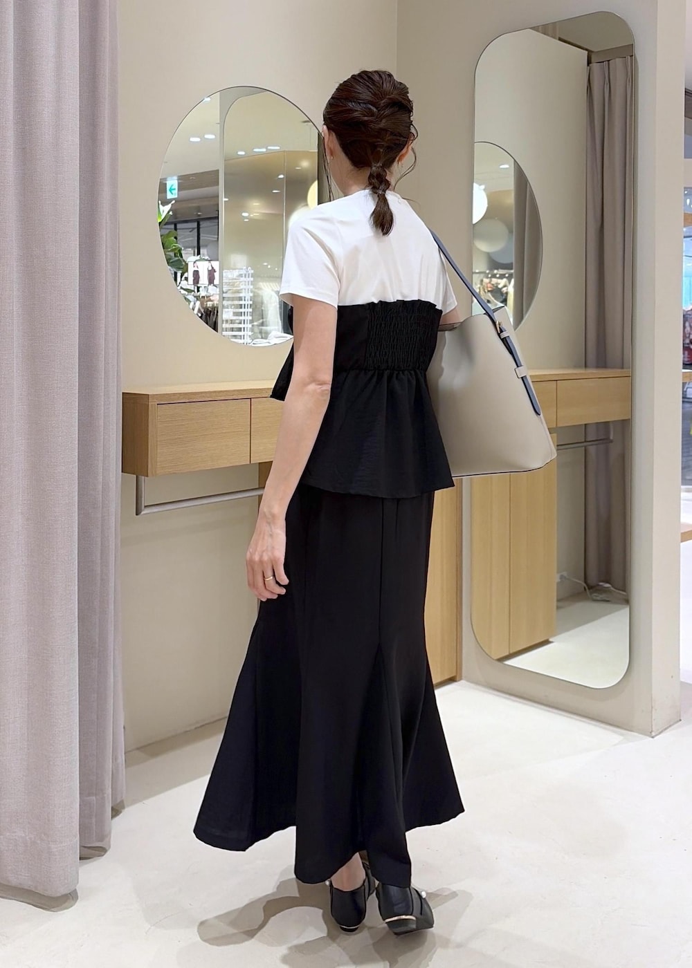 ベージュ系のトートバッグ、ブラック系のパンプス、ブラック系のTシャツ/カットソーを着用したレディースの春コーディネートの4枚目の写真