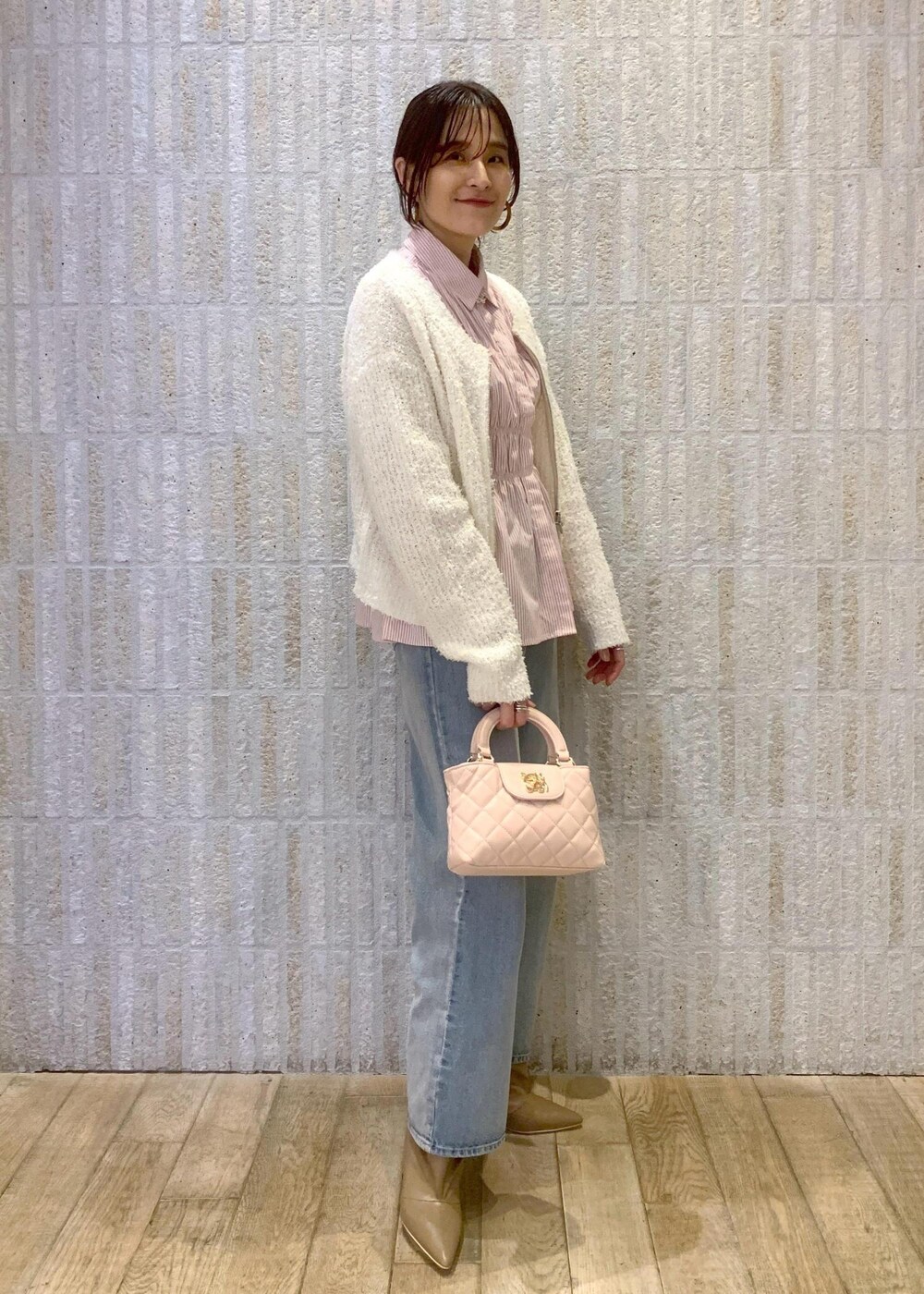 ベージュ系のブーツ、ブルー系のデニムパンツ、ピンク系のシャツ/ブラウスを着用したレディースの冬コーディネートの3枚目の写真