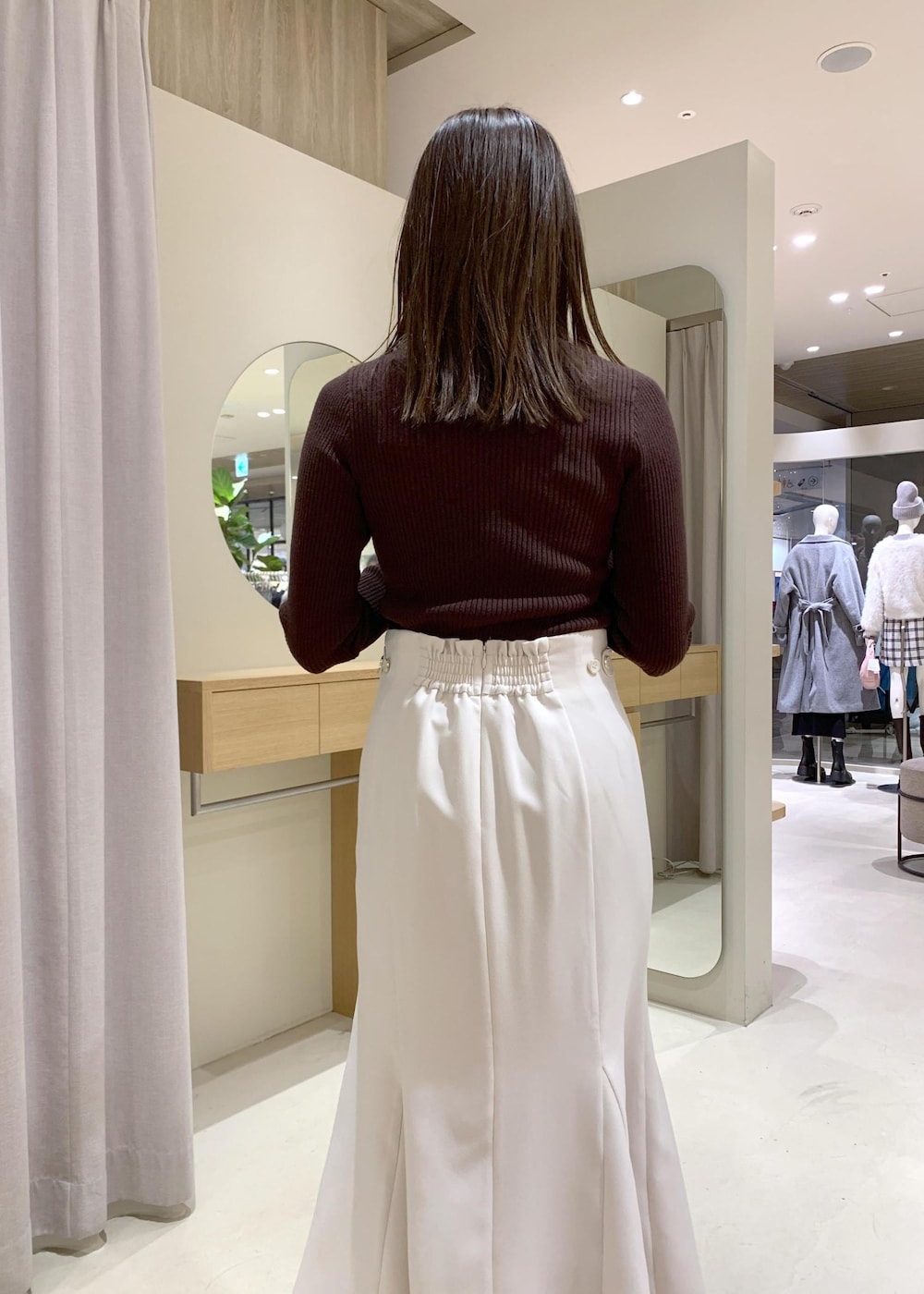 ブルー系のハンドバッグ、グレー系のその他アウター、ベージュ系のブーツを着用したレディースの冬コーディネートの9枚目の写真