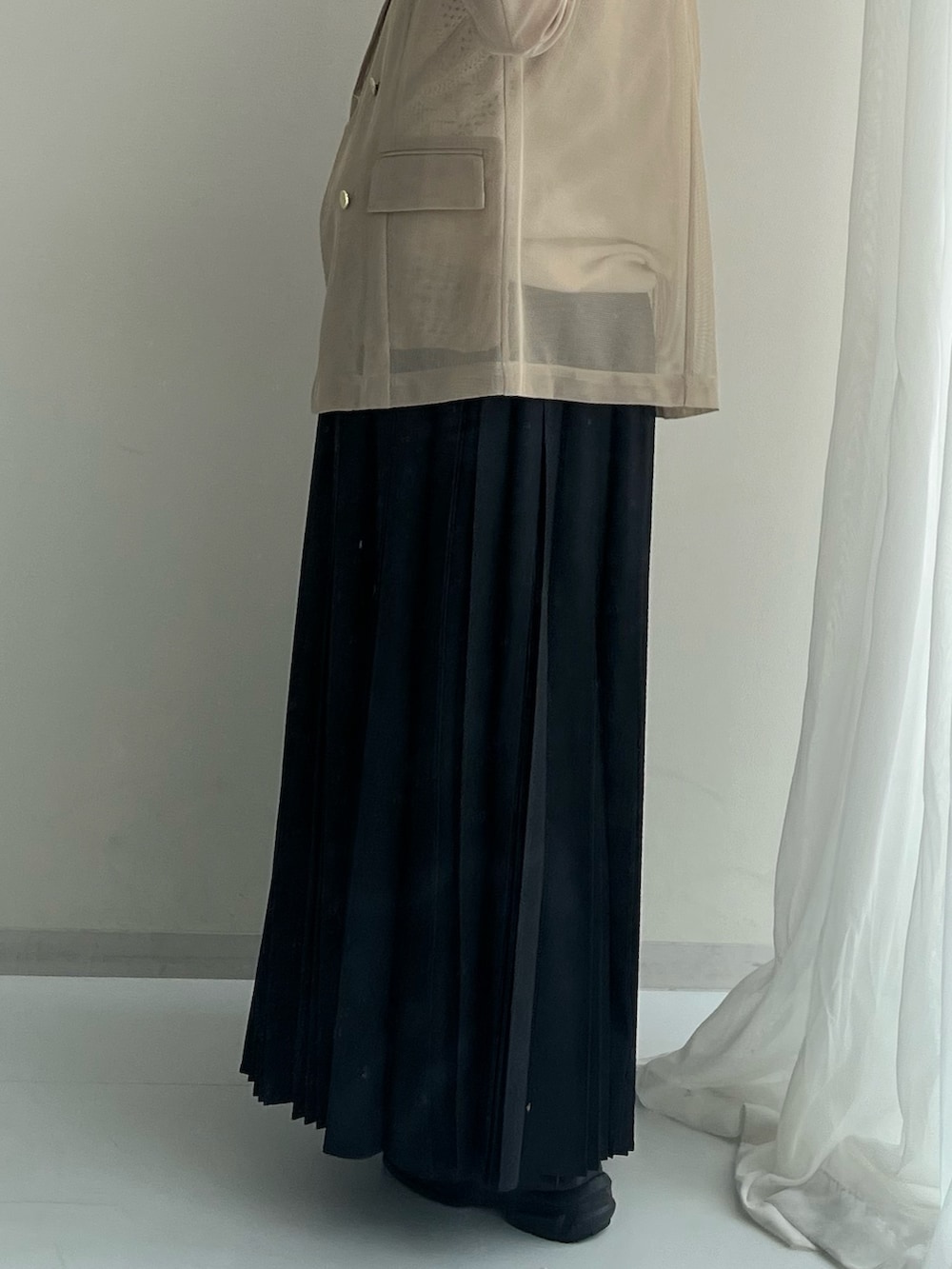 ブラック系のスニーカー、ブラック系のスカート、ブラウン系のジャケット/アウターを着用したレディースの春コーディネートの4枚目の写真