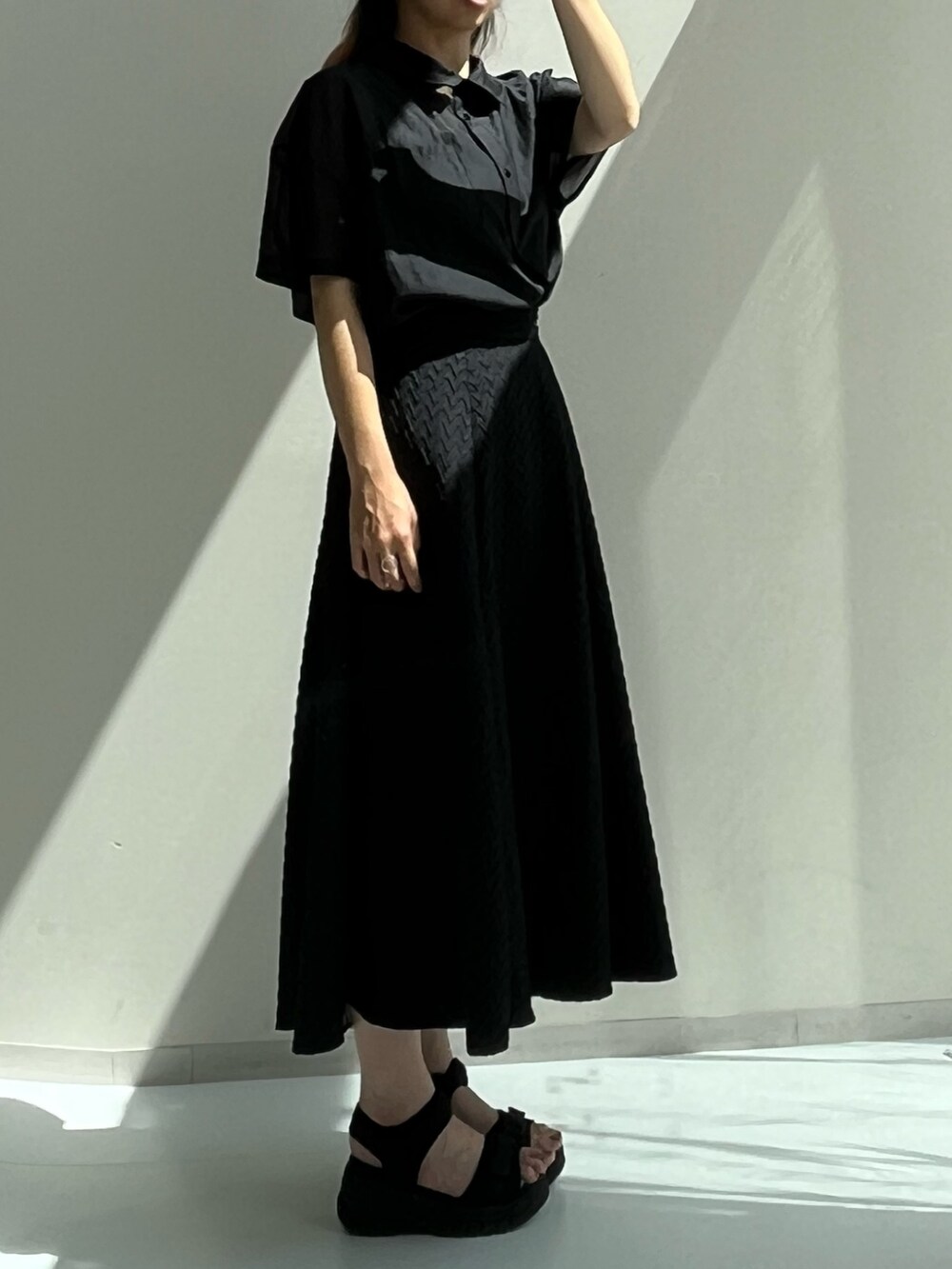 ブラック系のスカート、ブラック系のシャツ/ブラウス、ブラック系のサンダルを着用したレディースの夏コーディネートの2枚目の写真