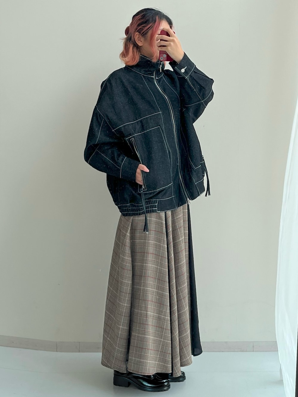 ブルー系のデニムジャケット、ブラウン系のスカートを着用したレディースの秋コーディネートの2枚目の写真