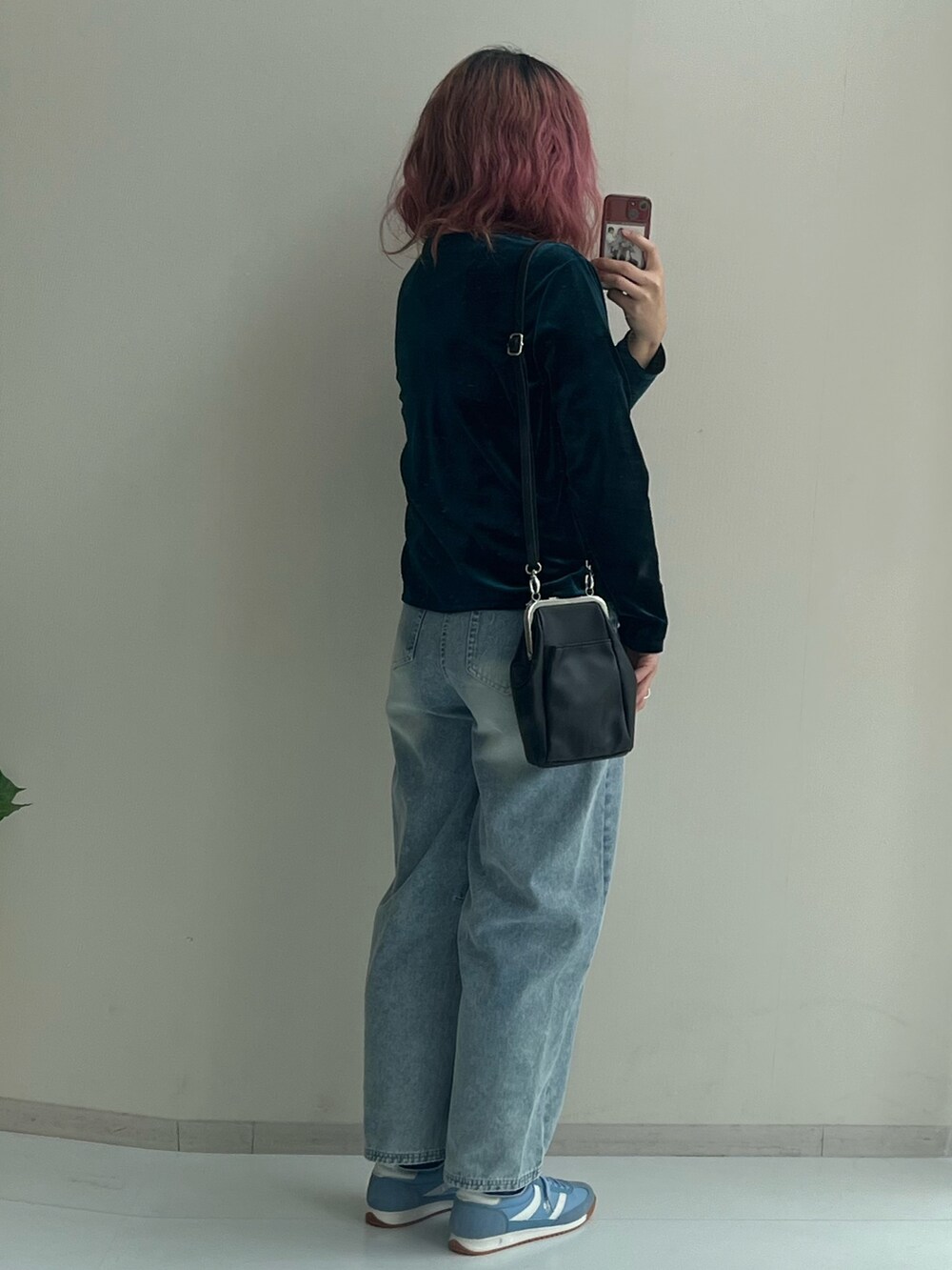 ブラック系のショルダーバッグ、ブルー系のパンツ、グリーン系のカーディガン/ボレロを着用したレディースの冬コーディネートの7枚目の写真