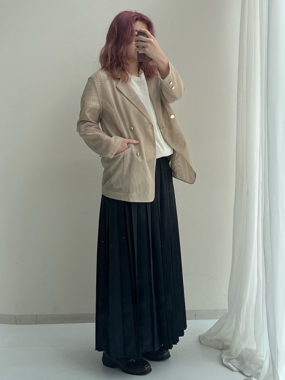 ブラック系のスニーカー、ブラック系のスカート、ブラウン系のジャケット/アウターを着用したレディースの春コーディネートの2枚目の写真