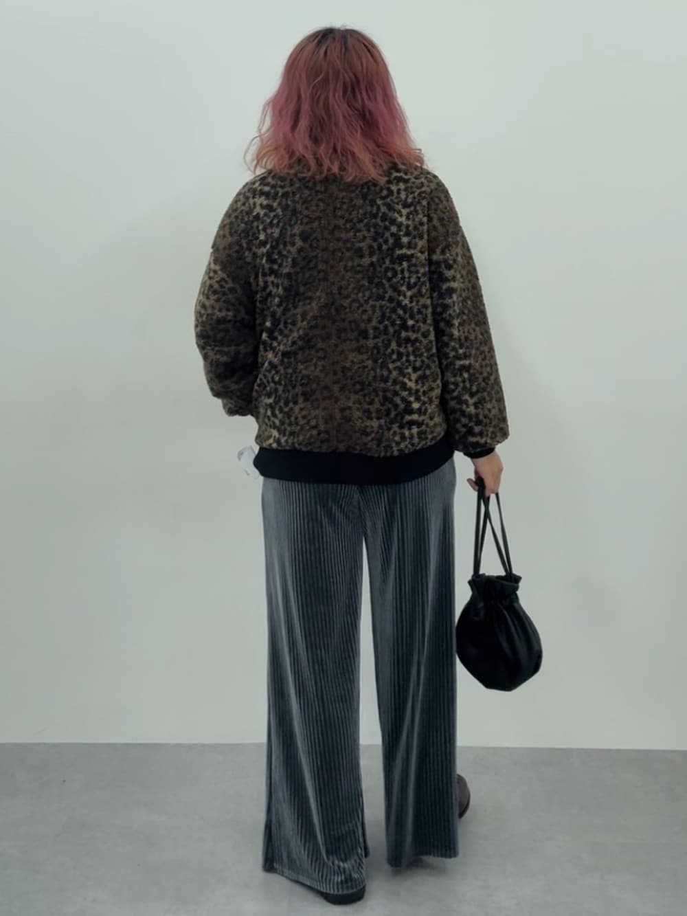 ブルー系のパンツ、ブラウン系のカーディガン/ボレロ、ブラウン系のスニーカーを着用したレディースの秋コーディネートの5枚目の写真