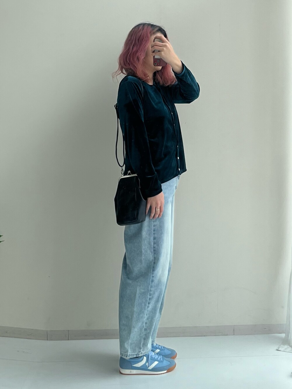 ブラック系のショルダーバッグ、ブルー系のパンツ、グリーン系のカーディガン/ボレロを着用したレディースの冬コーディネートの2枚目の写真