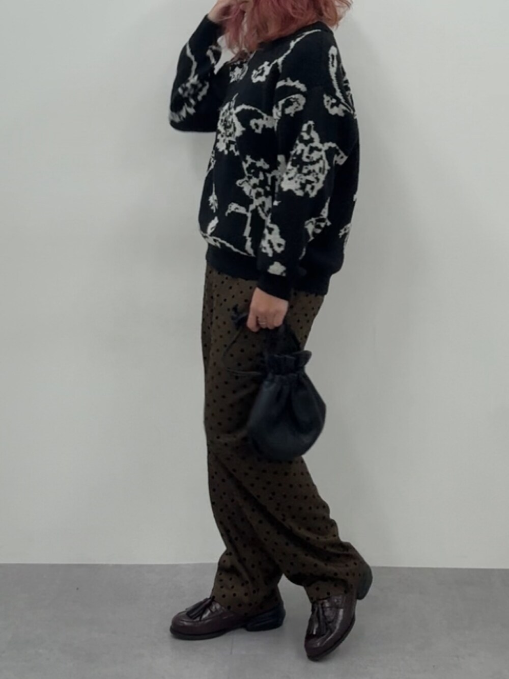 ブラウン系のスニーカー、ブラウン系のパンツ、ブラック系のニット/セーターを着用したレディースの冬コーディネートの4枚目の写真