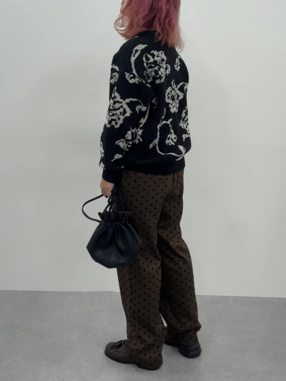 ブラウン系のスニーカー、ブラウン系のパンツ、ブラック系のニット/セーターを着用したレディースの冬コーディネートの7枚目の写真