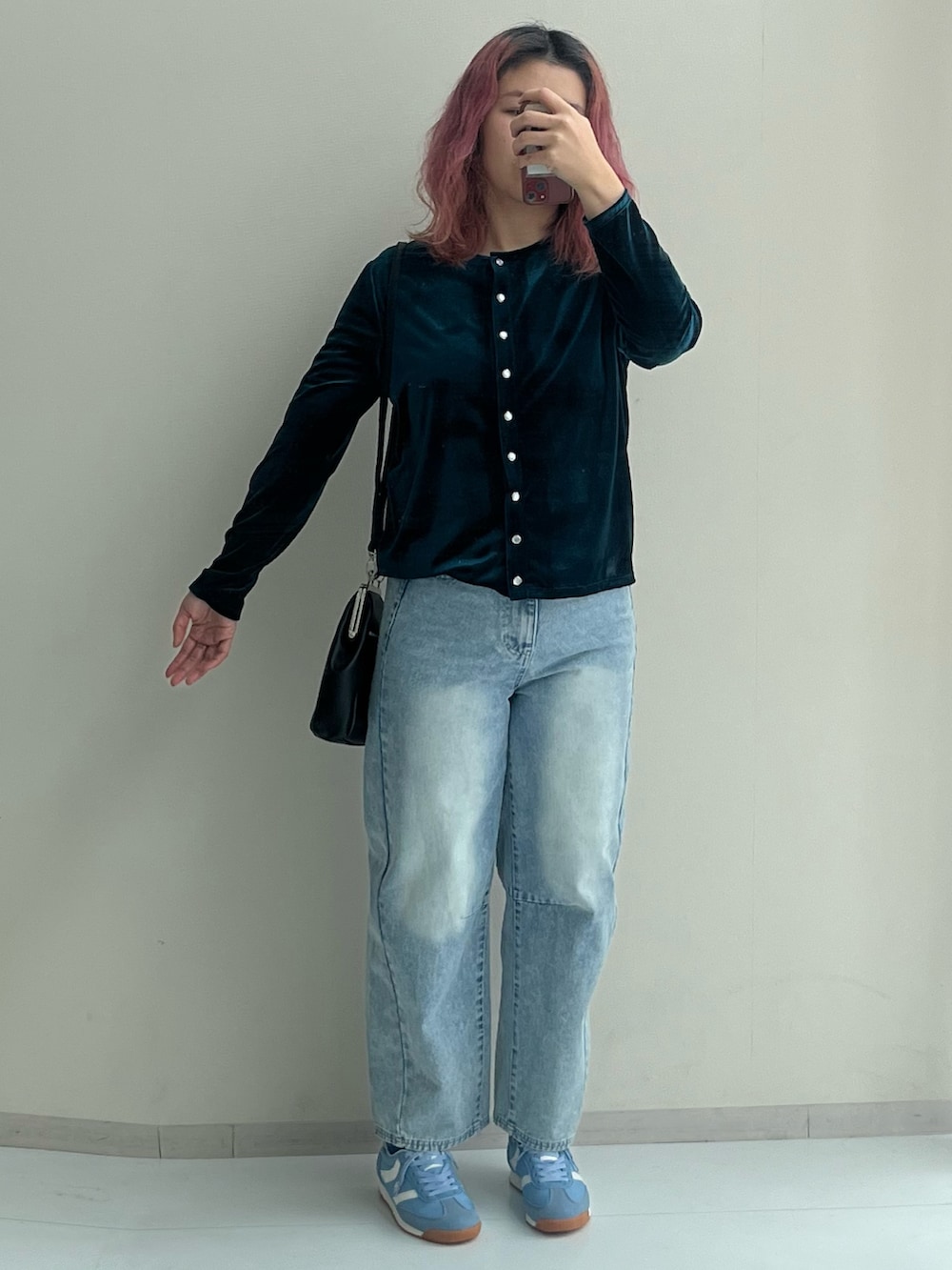 ブラック系のショルダーバッグ、ブルー系のパンツ、グリーン系のカーディガン/ボレロを着用したレディースの冬コーディネートの5枚目の写真