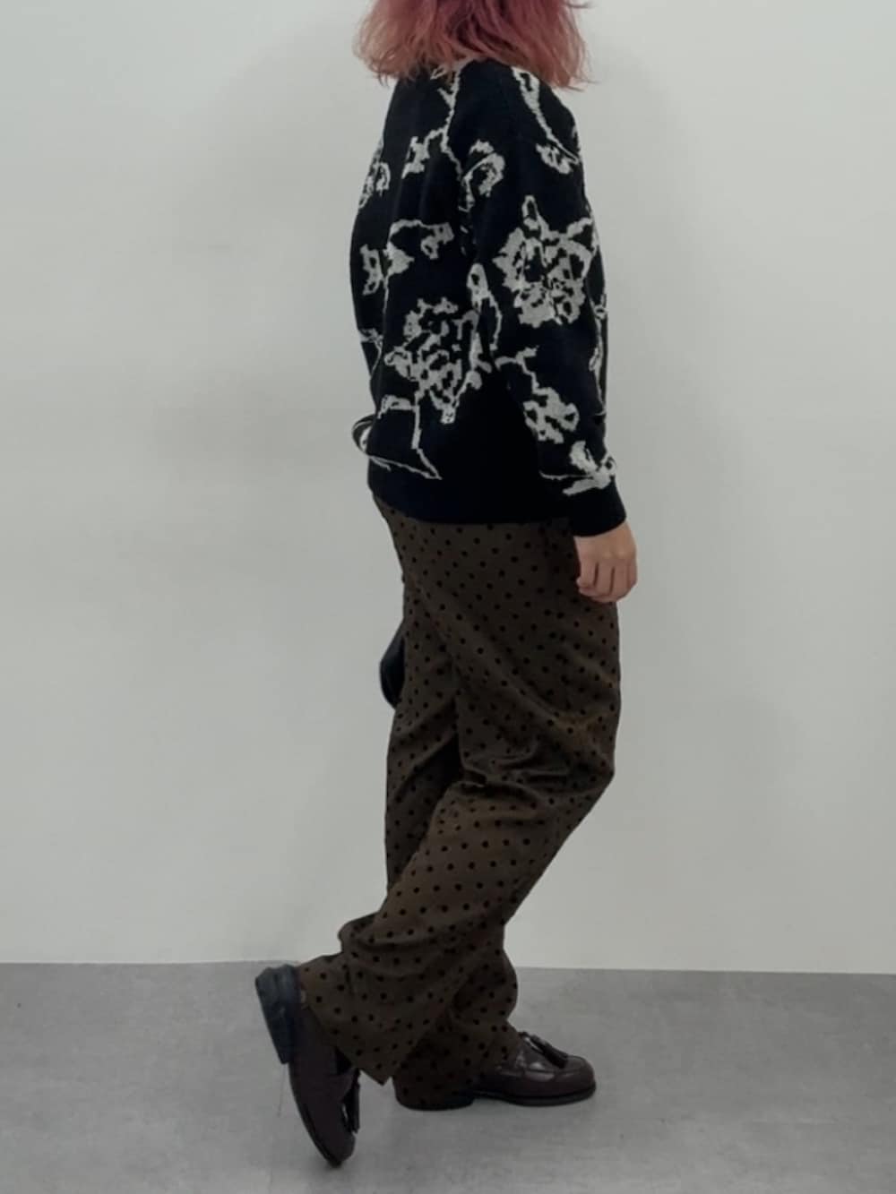 ブラウン系のスニーカー、ブラウン系のパンツ、ブラック系のニット/セーターを着用したレディースの冬コーディネートの6枚目の写真