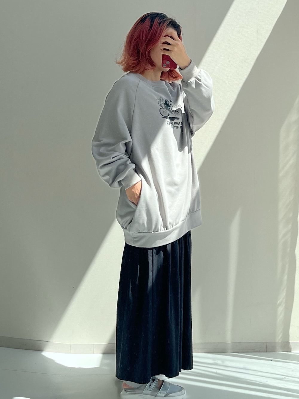 シルバー系のスニーカー、ブラック系のスウェット、ブラック系のパンツを着用したレディースの秋コーディネートの2枚目の写真