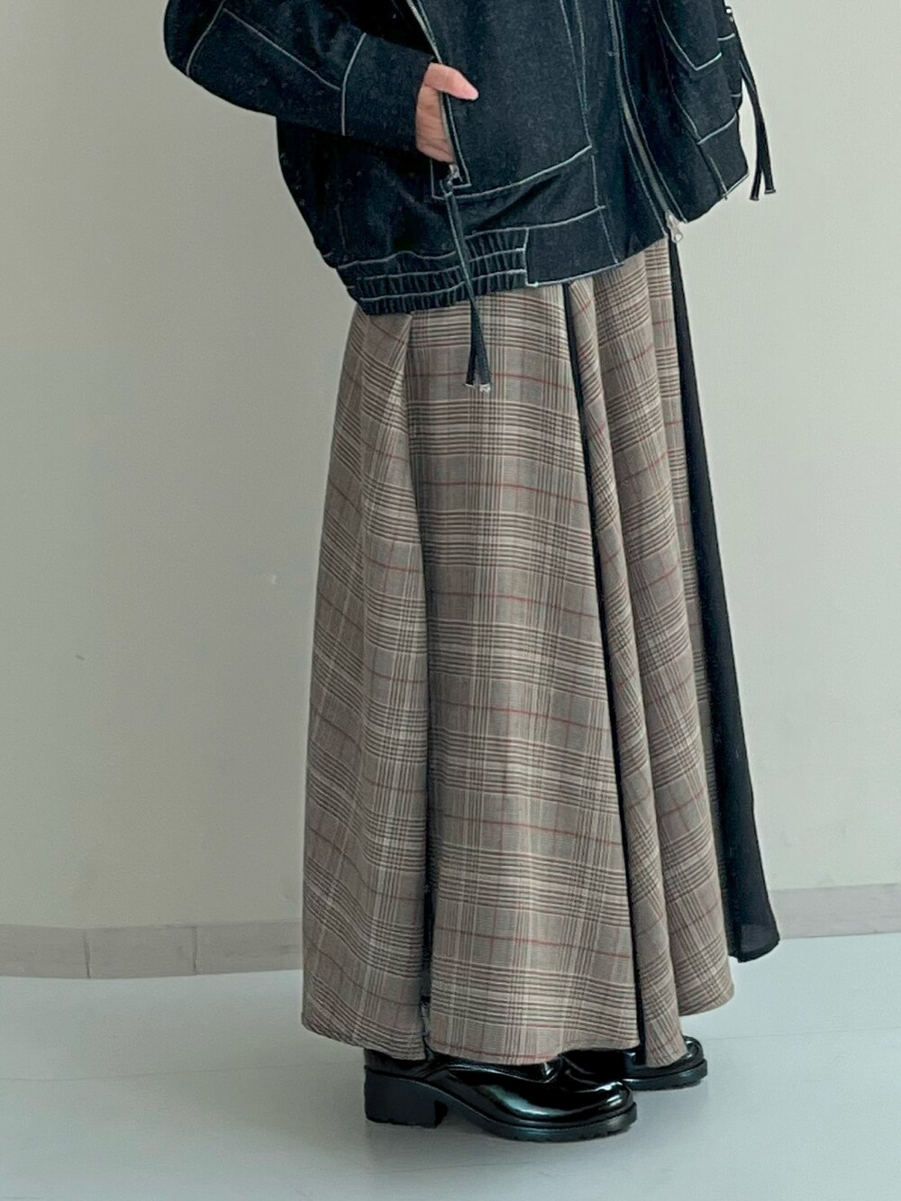 ブルー系のデニムジャケット、ブラウン系のスカートを着用したレディースの秋コーディネートの6枚目の写真