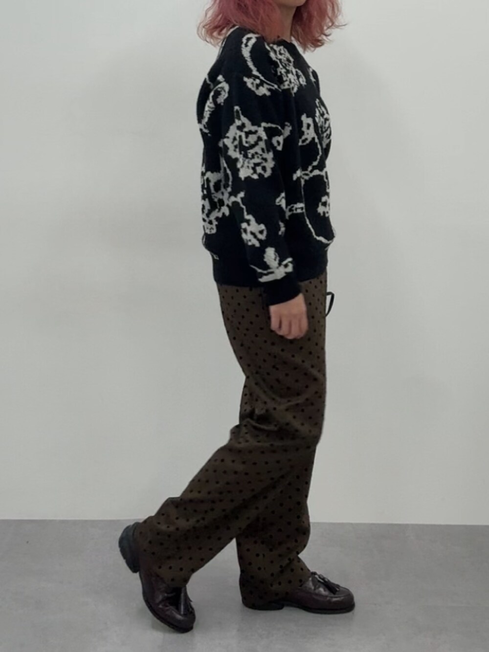 ブラウン系のスニーカー、ブラウン系のパンツ、ブラック系のニット/セーターを着用したレディースの冬コーディネートの5枚目の写真