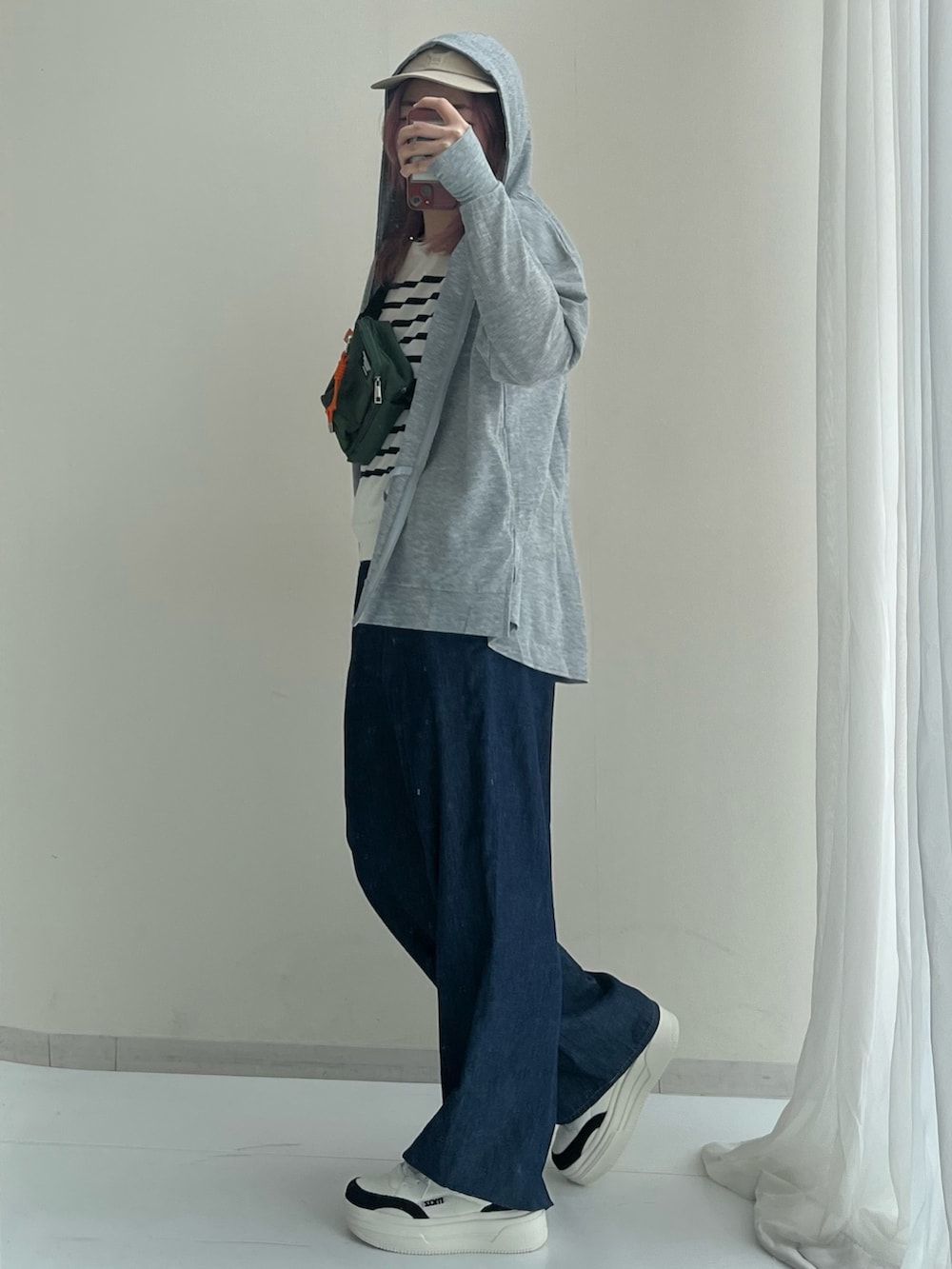 グレー系のセットアップ、ホワイト系のニット/セーター、ブラック系のスニーカーを着用したレディースの春コーディネートの4枚目の写真