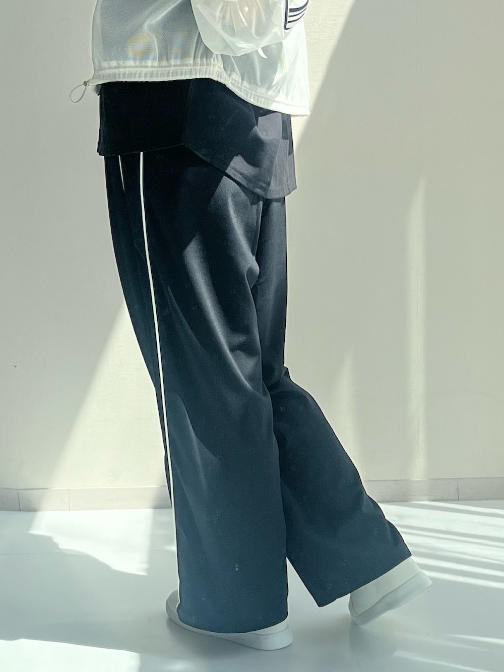 ブラック系のパンツ、ホワイト系のジャケット/アウター、ブラック系のTシャツ/カットソーを着用したレディースの秋コーディネートの3枚目の写真