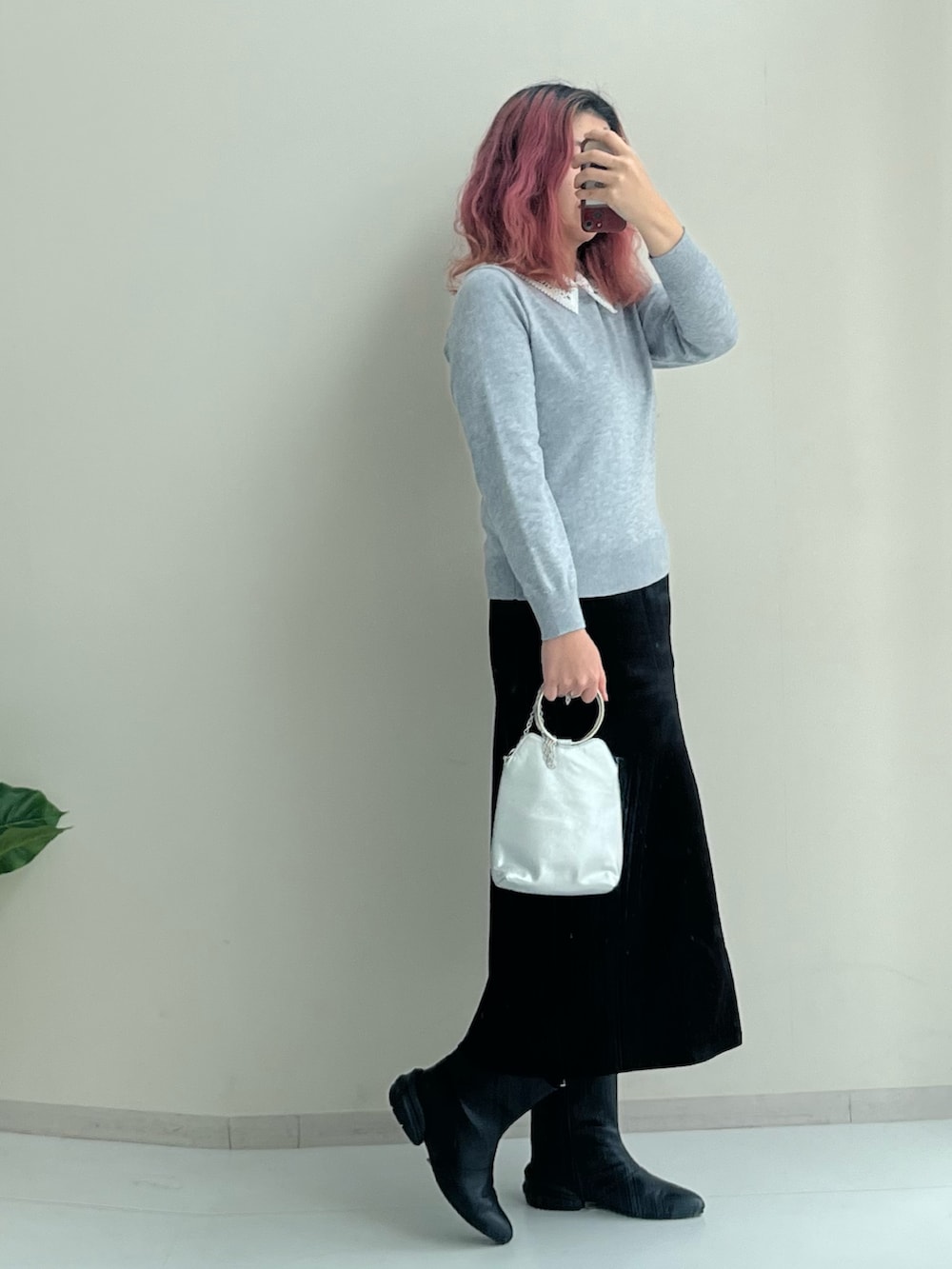 ブラック系のスカート、ブラック系のブーツ、グレー系のニット/セーターを着用したレディースの冬コーディネートの3枚目の写真