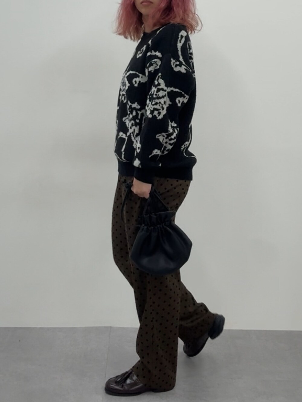 ブラウン系のスニーカー、ブラウン系のパンツ、ブラック系のニット/セーターを着用したレディースの冬コーディネートの3枚目の写真