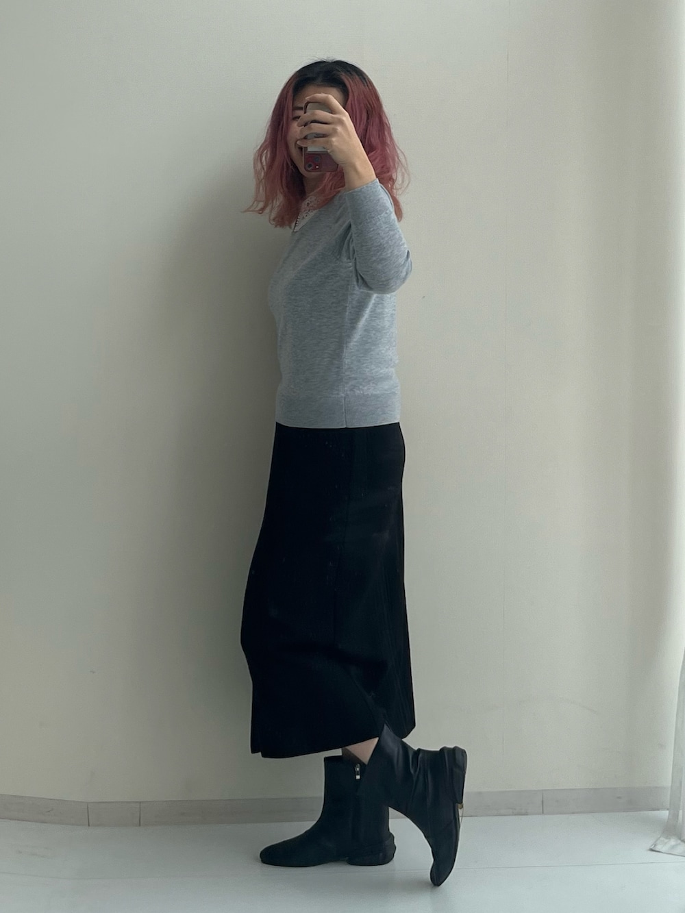 ブラック系のスカート、ブラック系のブーツ、グレー系のニット/セーターを着用したレディースの冬コーディネートの6枚目の写真