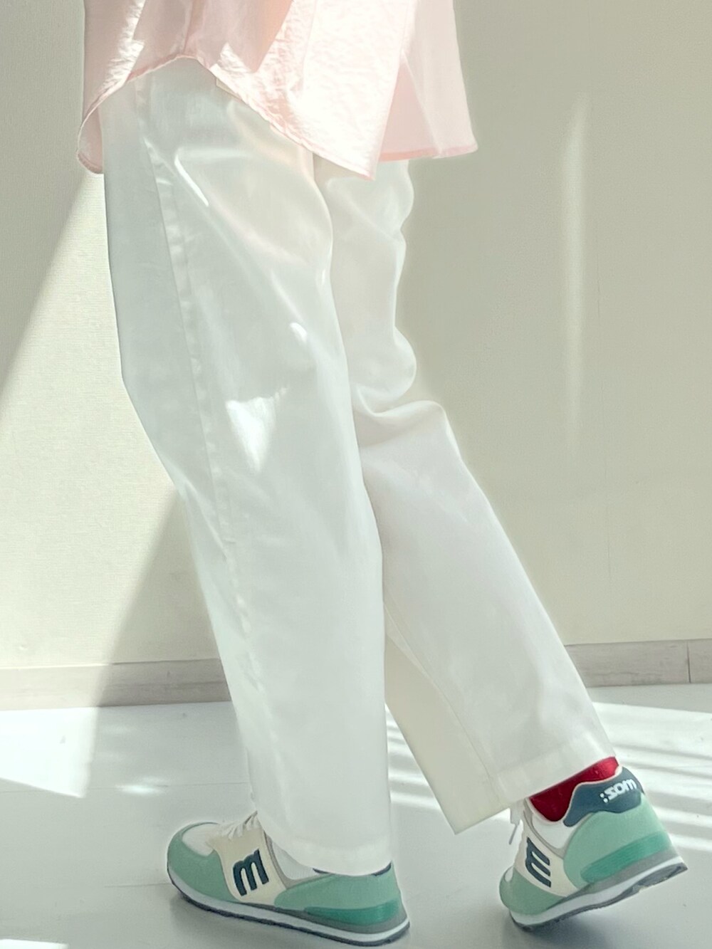 ピンク系のシャツ/ブラウス、ホワイト系のパンツ、レッド系のスニーカーを着用したレディースの秋コーディネートの3枚目の写真