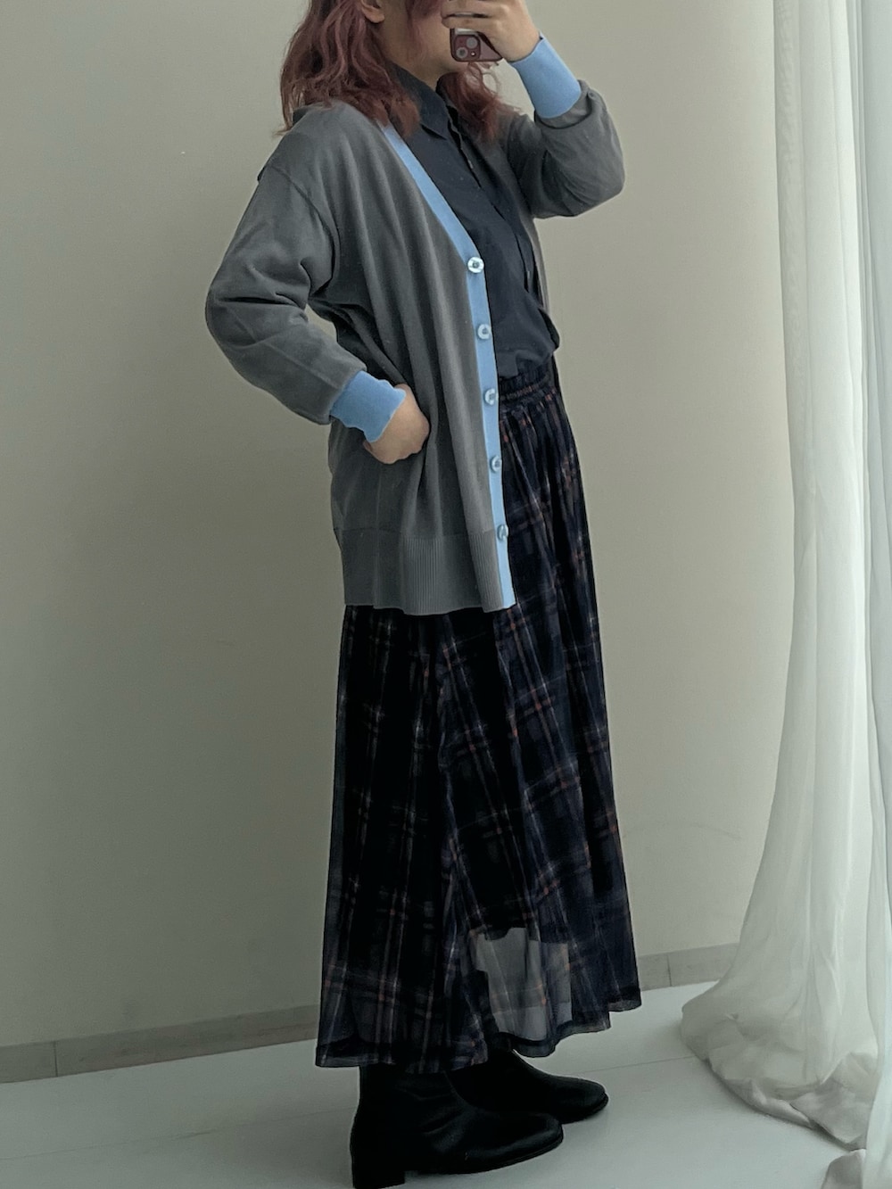 ブルー系のスカート、グレー系のカーディガン/ボレロ、ブラック系のブーツを着用したレディースの春コーディネートの7枚目の写真