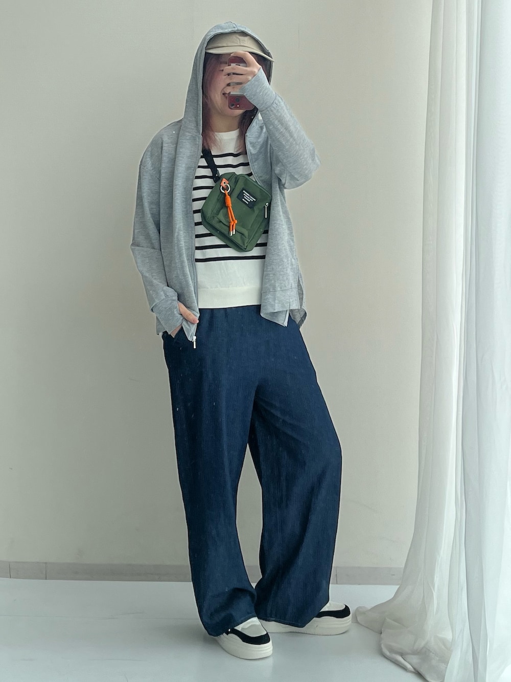 グレー系のセットアップ、ホワイト系のニット/セーター、ブラック系のスニーカーを着用したレディースの春コーディネートの3枚目の写真