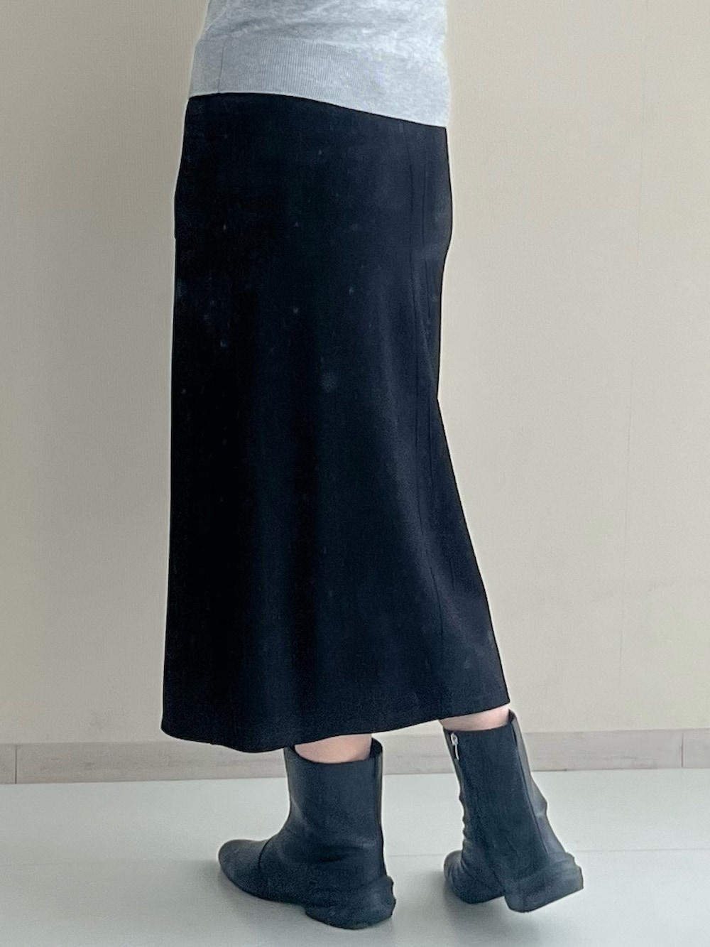 ブラック系のスカート、ブラック系のブーツ、グレー系のニット/セーターを着用したレディースの冬コーディネートの7枚目の写真