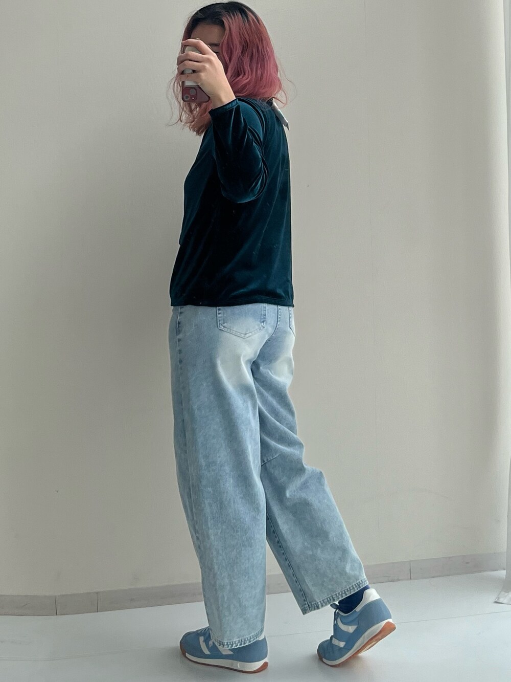 ブラック系のショルダーバッグ、ブルー系のパンツ、グリーン系のカーディガン/ボレロを着用したレディースの冬コーディネートの6枚目の写真