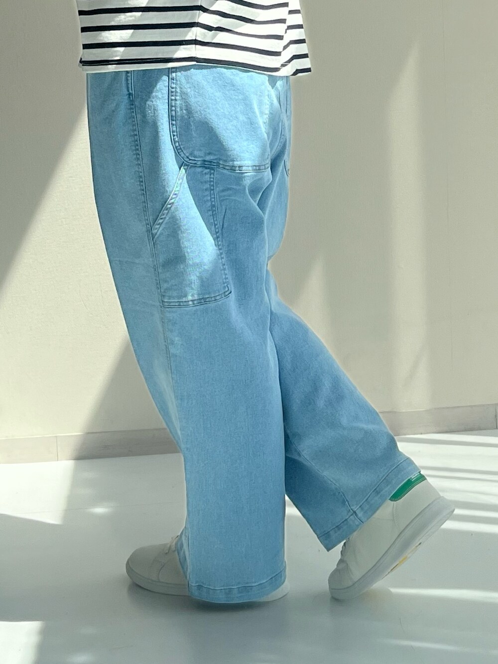 ブルー系のパンツ、シルバー系のTシャツ/カットソー、ホワイト系のスニーカーを着用したレディースの秋コーディネートの3枚目の写真