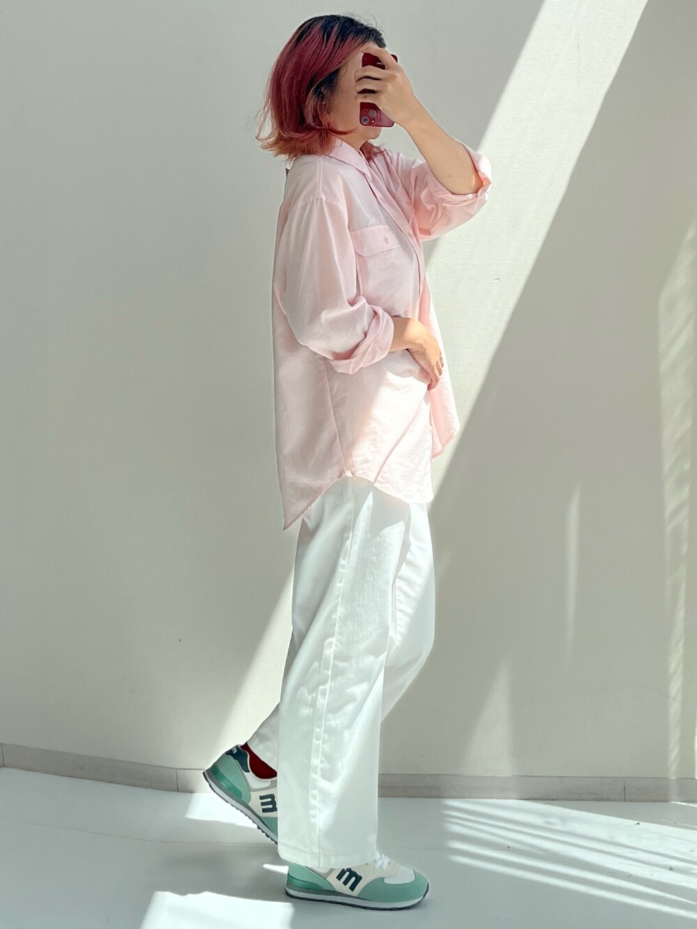 ピンク系のシャツ/ブラウス、ホワイト系のパンツ、レッド系のスニーカーを着用したレディースの秋コーディネートの2枚目の写真