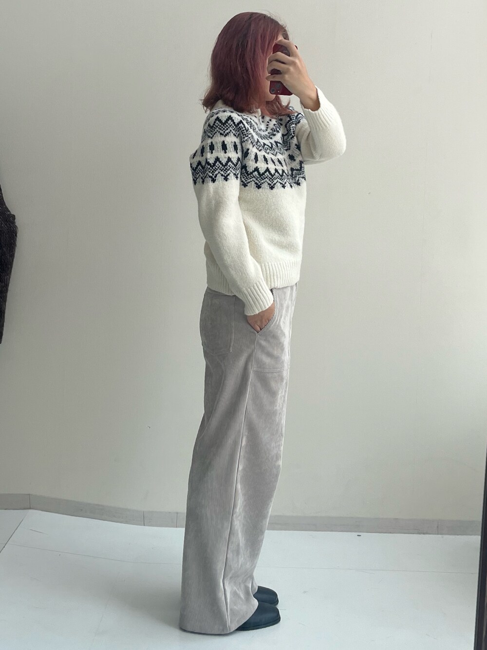 ブラック系のブーツ、ホワイト系のニット/セーター、ホワイト系のその他パンツを着用したレディースの秋コーディネートの2枚目の写真