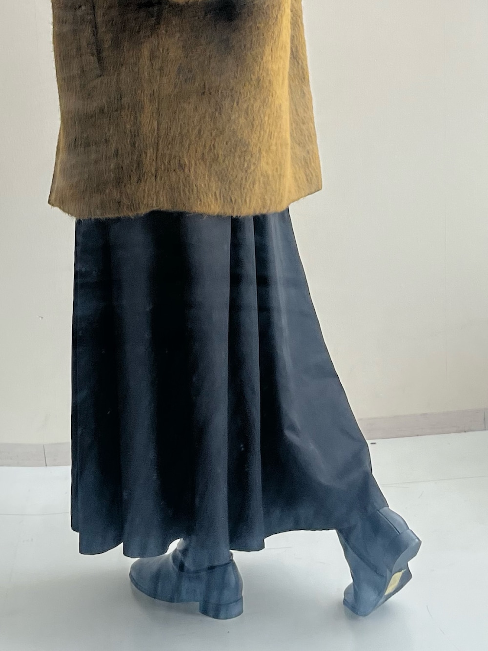 ブラック系のブーツ、ブラック系のスカート、イエロー系のジャケット/アウターを着用したレディースの秋コーディネートの5枚目の写真