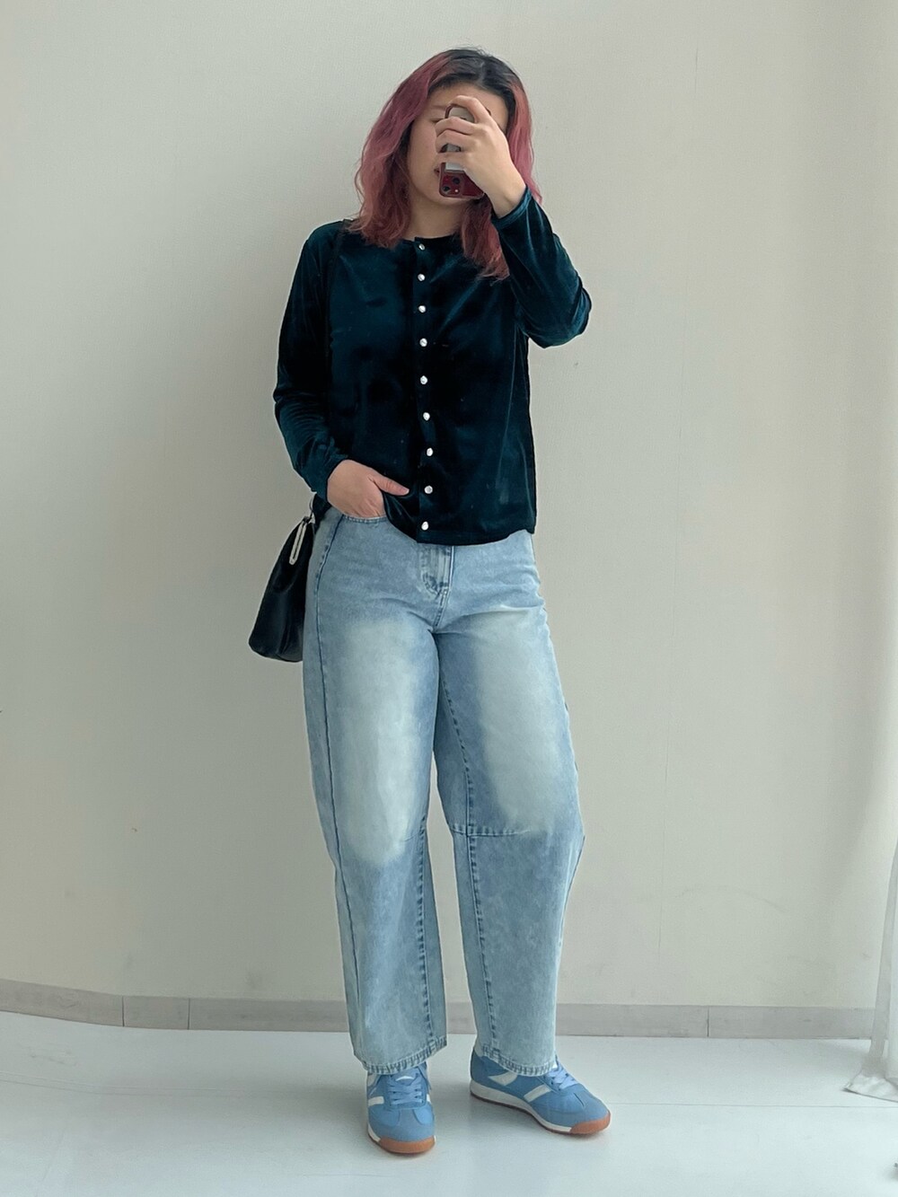 ブラック系のショルダーバッグ、ブルー系のパンツ、グリーン系のカーディガン/ボレロを着用したレディースの冬コーディネートの4枚目の写真