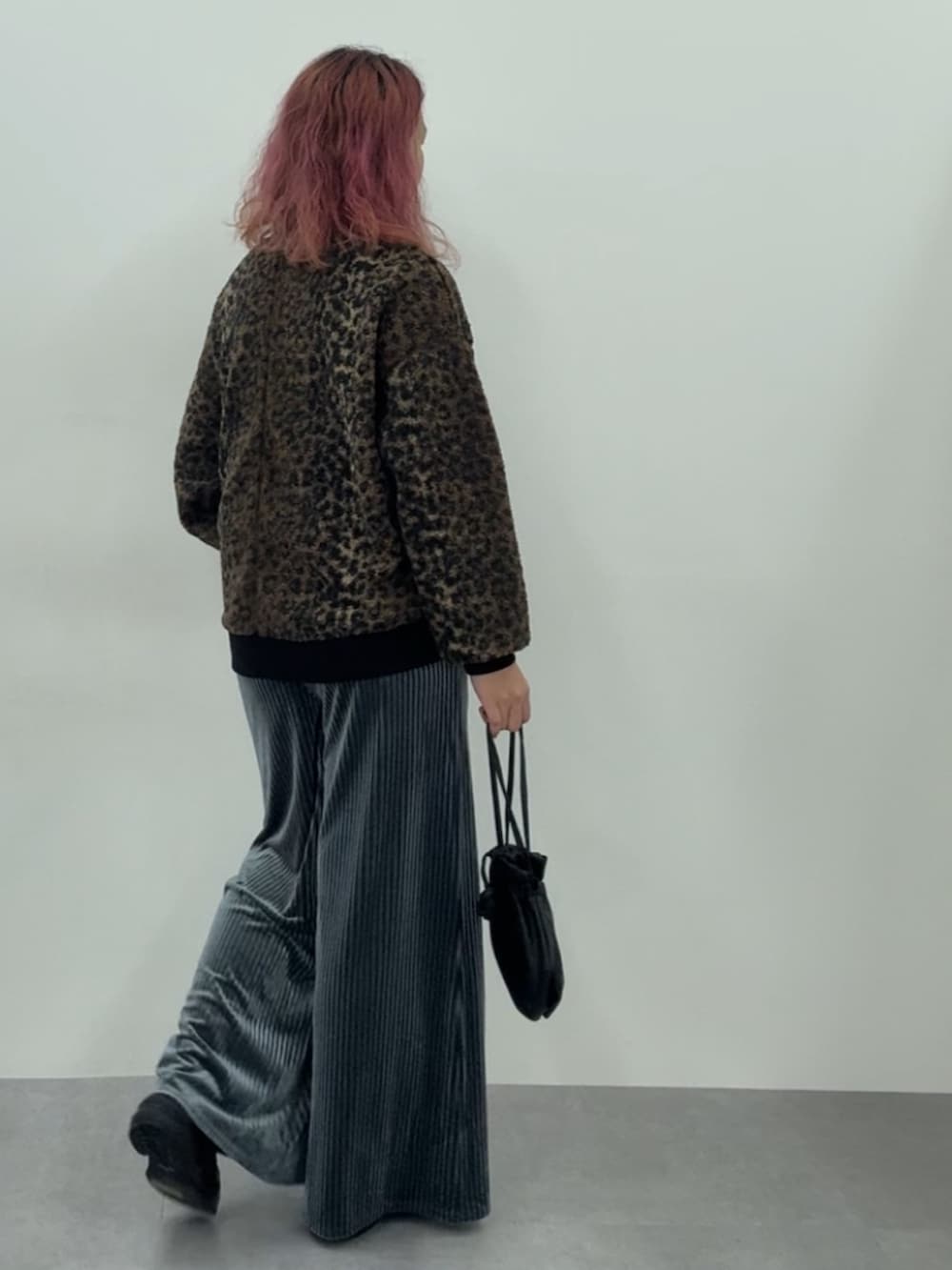 ブルー系のパンツ、ブラウン系のカーディガン/ボレロ、ブラウン系のスニーカーを着用したレディースの秋コーディネートの4枚目の写真